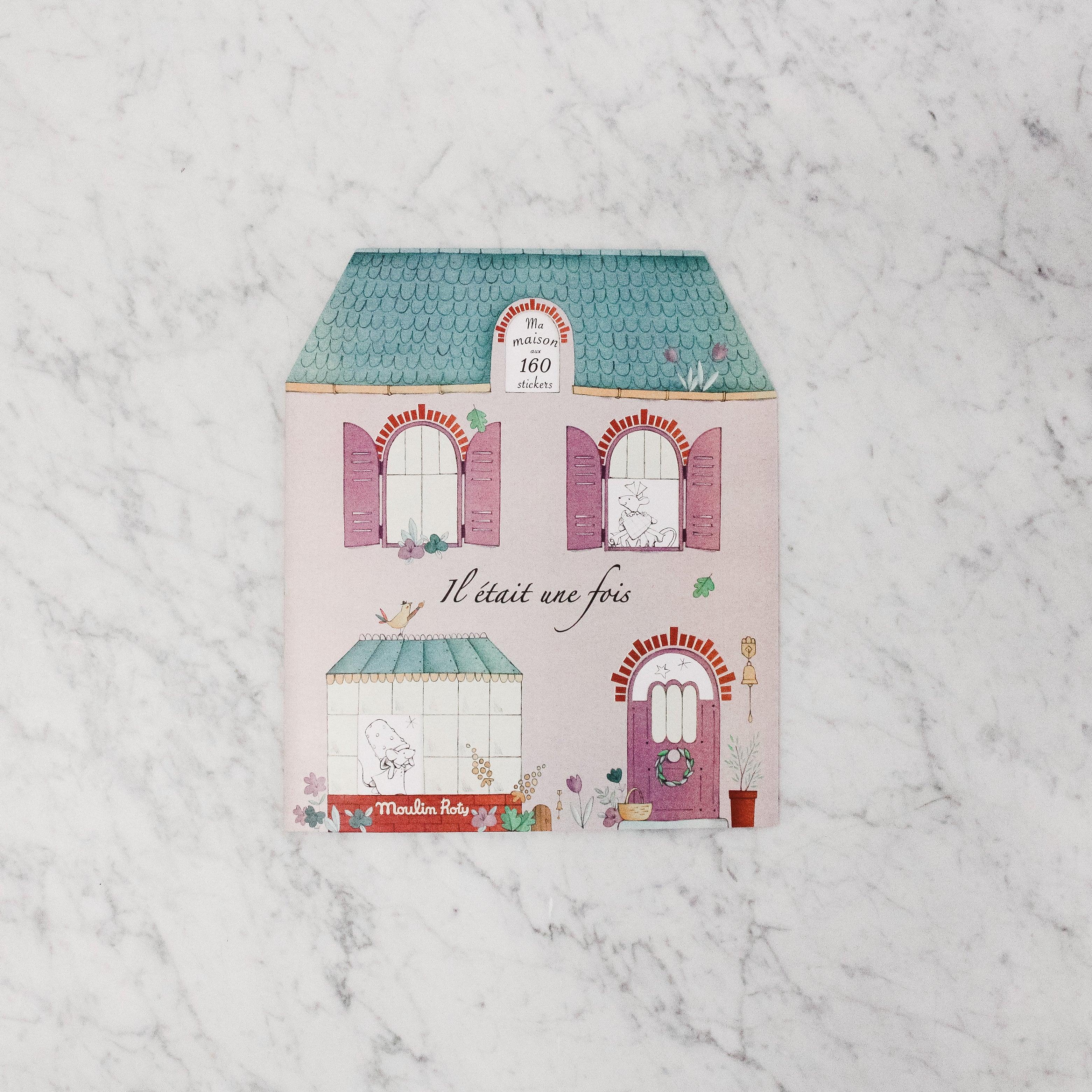 The Moulin Roty - Ma Maison Sticker Book by Grace & Company features French text and animals in windows on a pastel house.