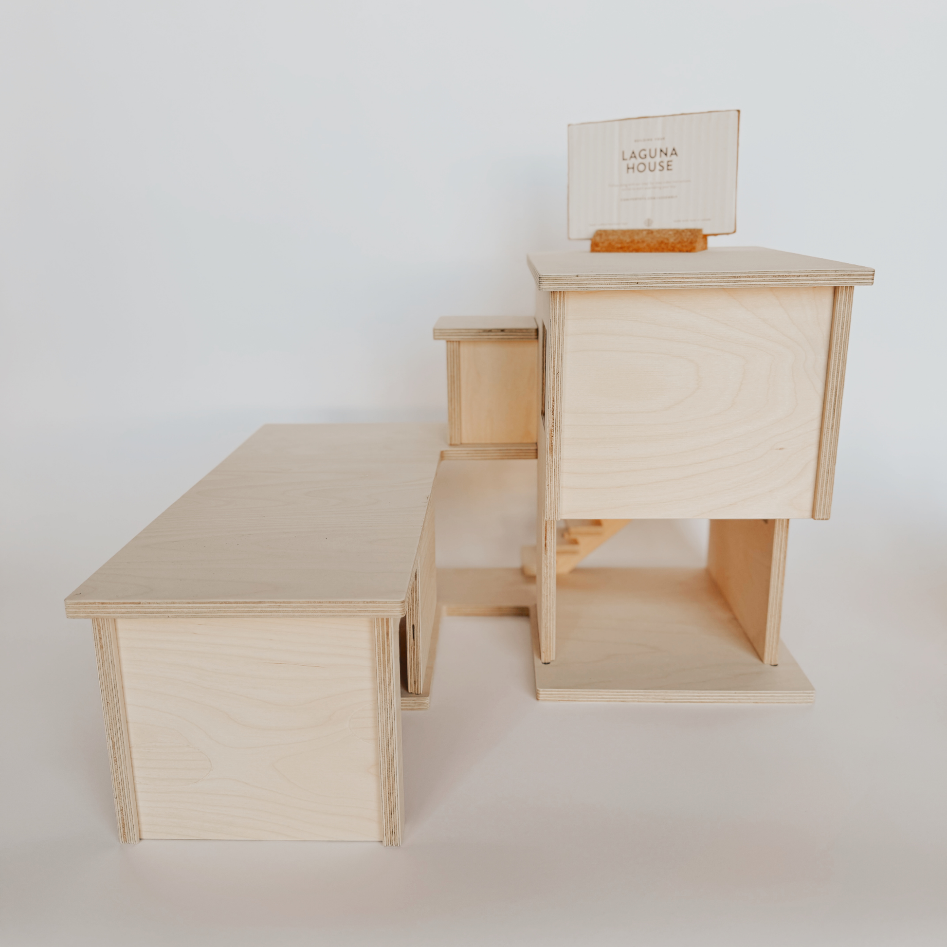 Grace & Company’s Laguna House: a minimalist wooden house model with a “Laguna House” sign on top.