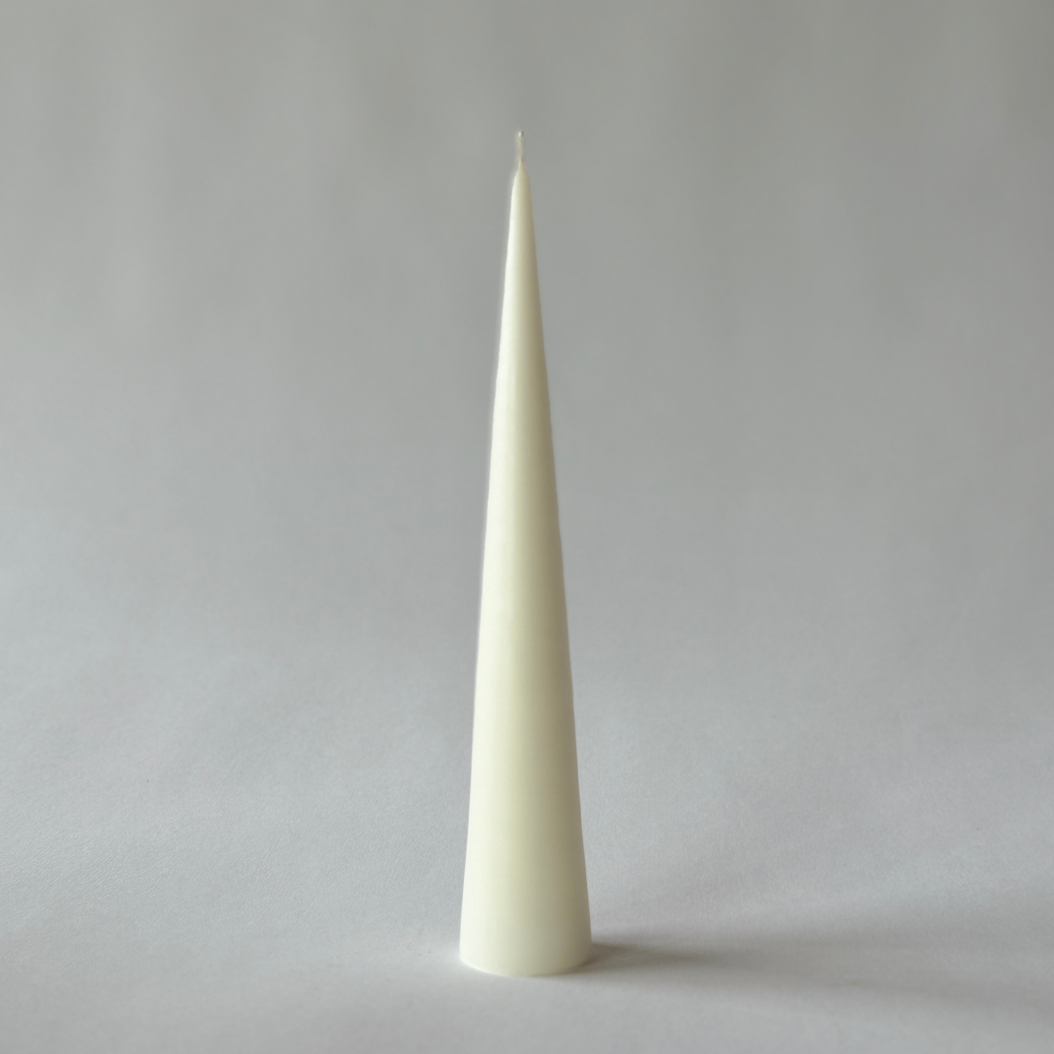 Ester & Erik Cone Candle by Grace & Company Ltd: tall, white, cone-shaped, upright on a light gray background.