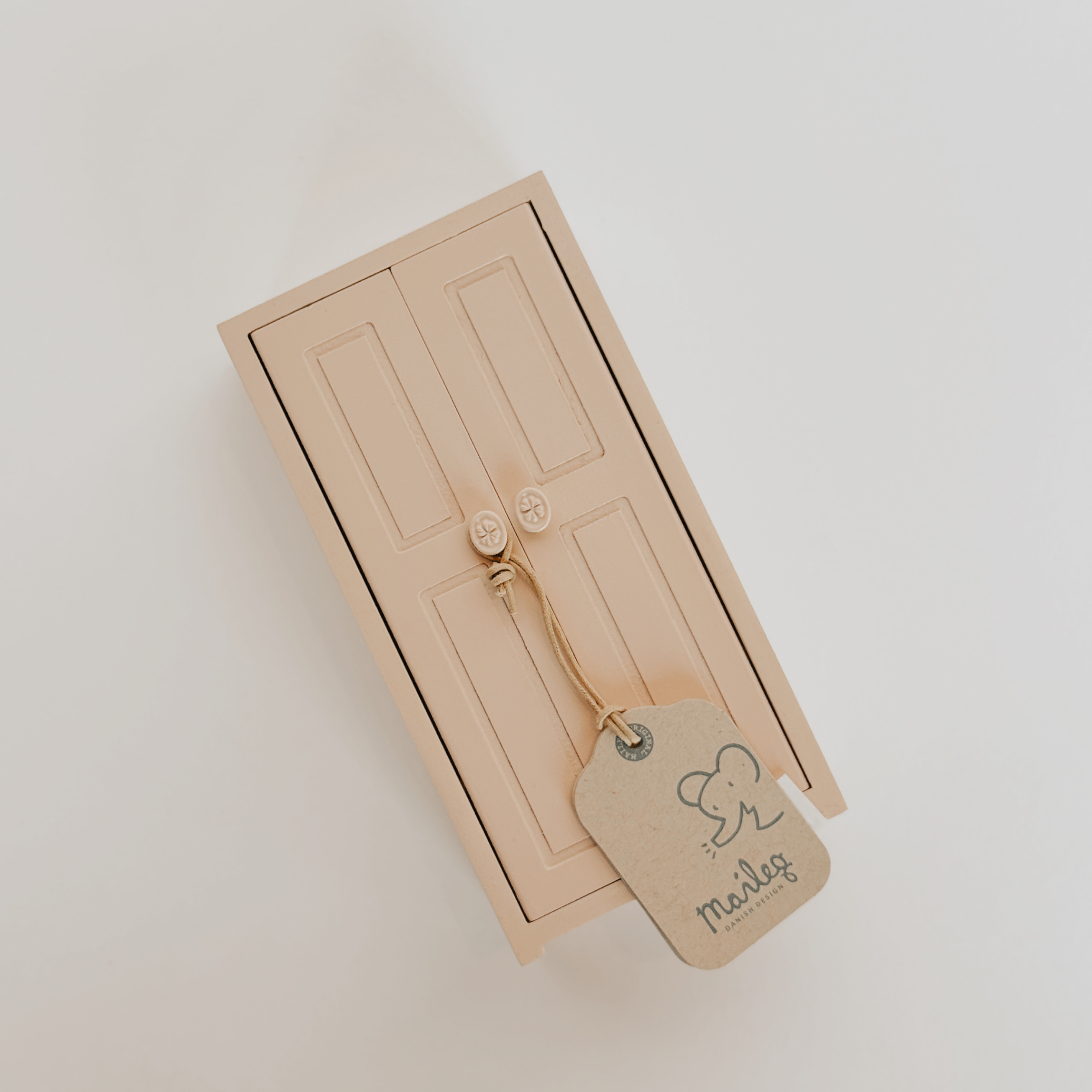 Small beige Maileg - Wooden Closet by Grace and Company Ltd with round knobs, brown tag, and elephant detail.