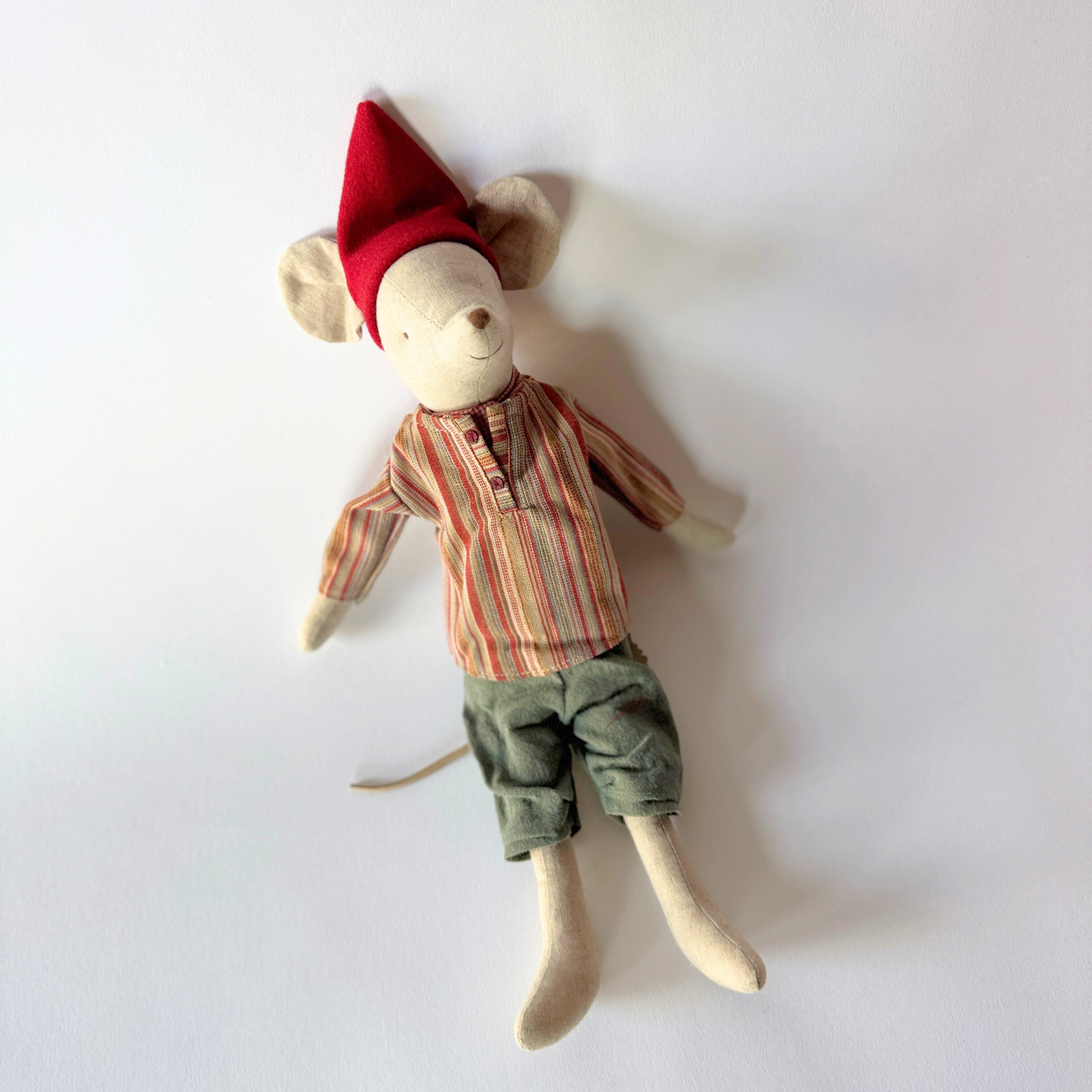 Grace & Company Maileg Christmas Mouse stuffed toy wears a red hat, striped shirt, and green pants.