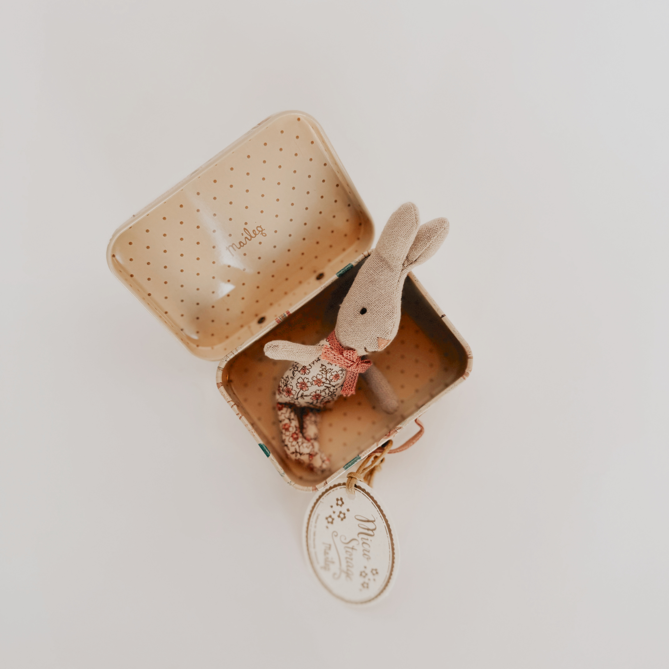 Grace & Company Maileg Micro Bunny in a floral outfit with suitcase, round tag attached, on white background.
