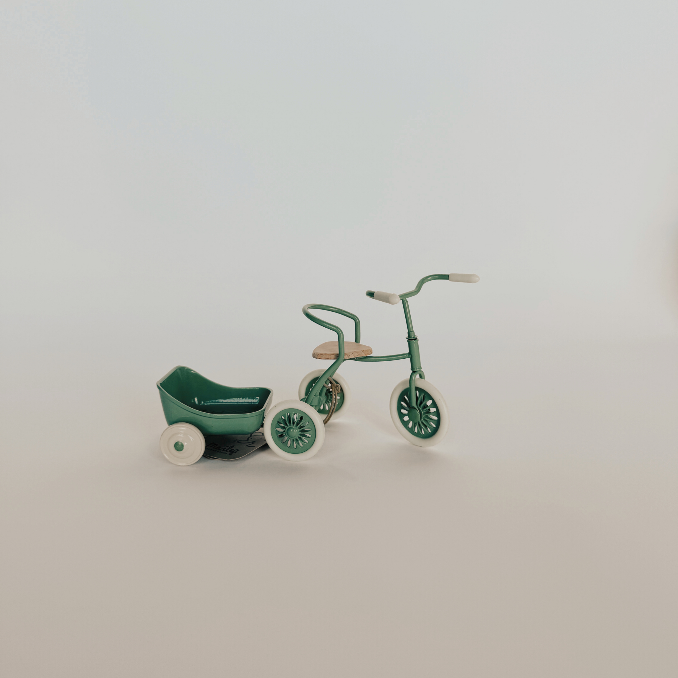 Grace & Company Maileg - Abri Tricycle + Hanger in green and white shown on a plain, light background.