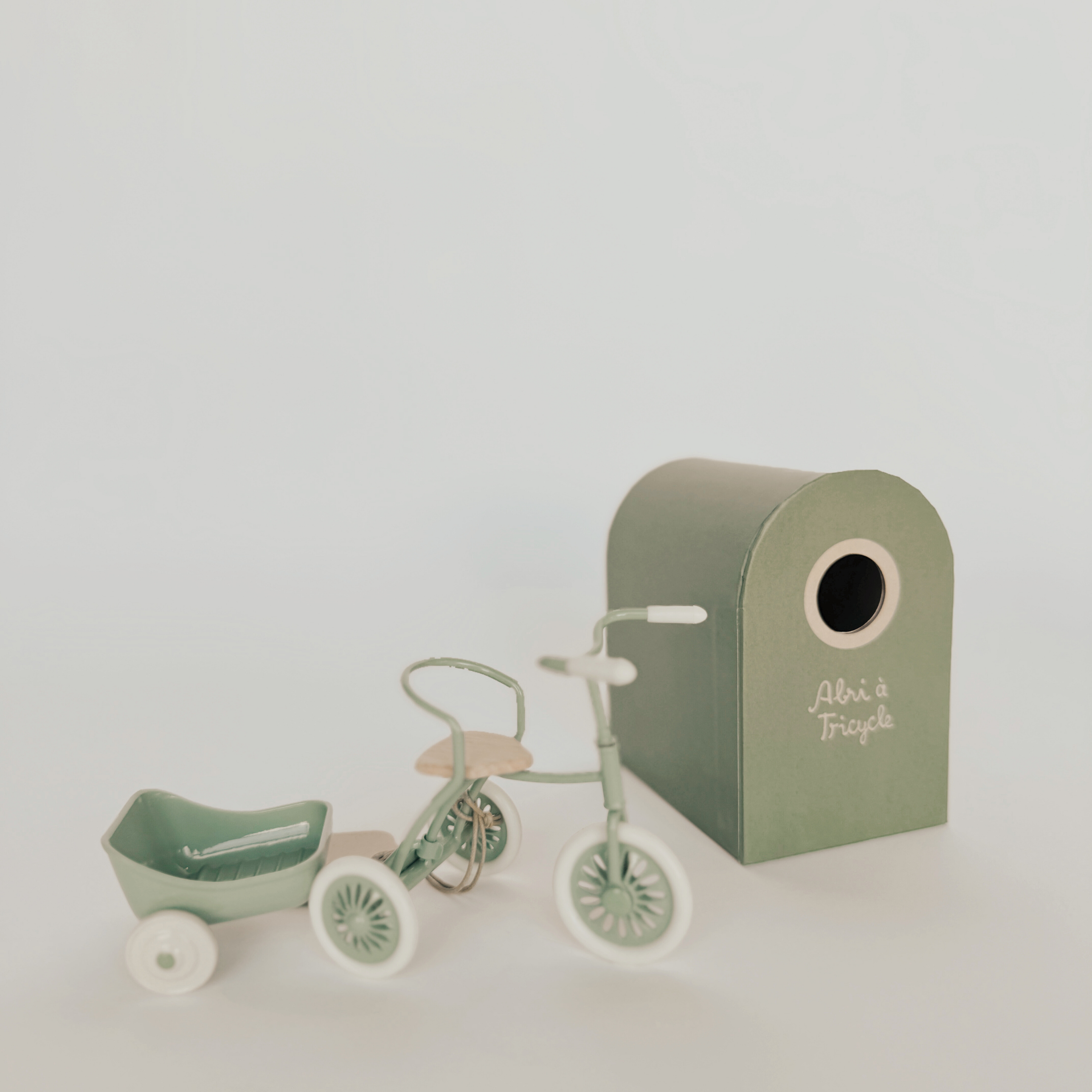 Grace & Company Maileg Abri Tricycle + Hanger in pastel green with trailer and matching mailbox on white background.