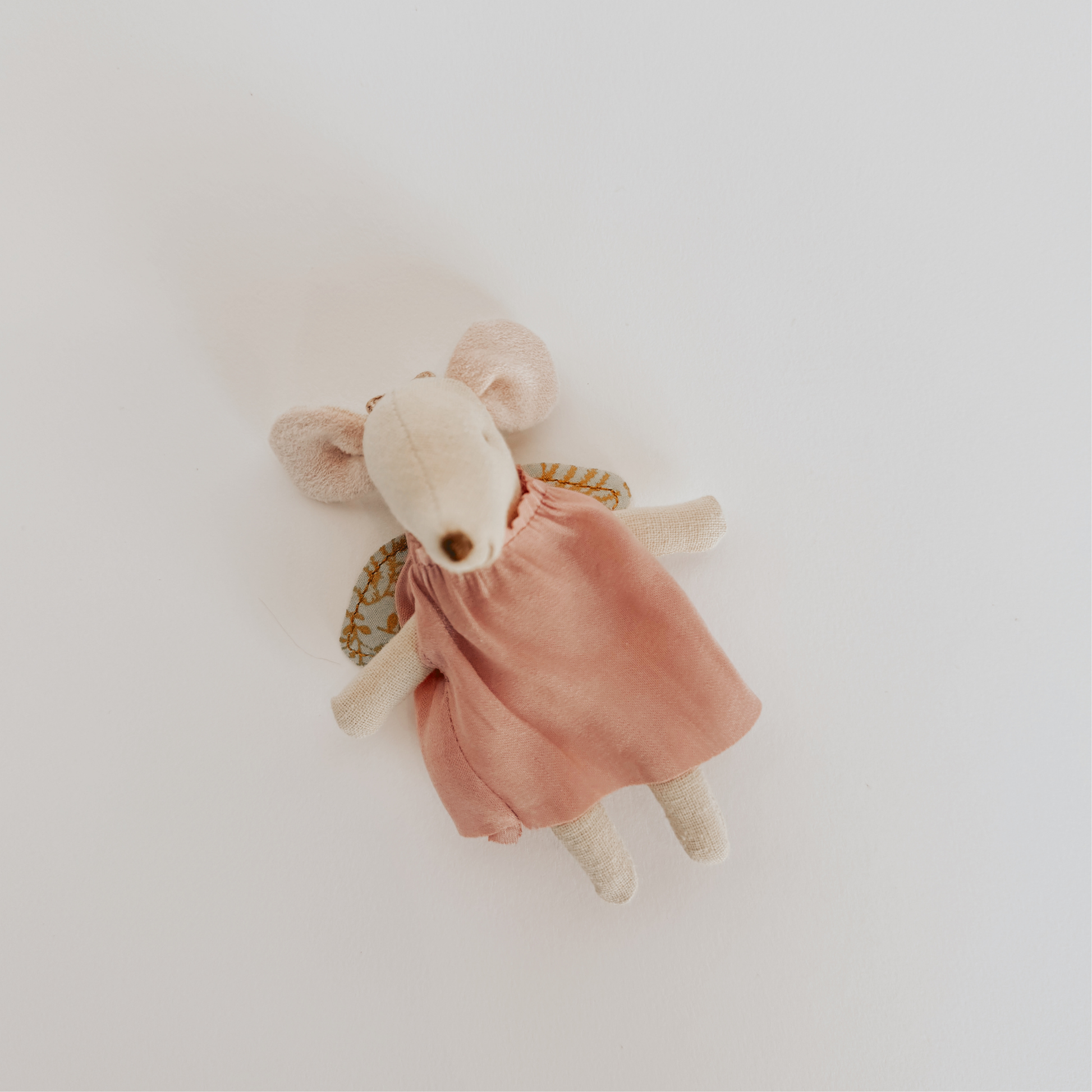 Grace & Company’s Maileg Guardian Mouse in a Suitcase wears a pink dress and lies on a white background.