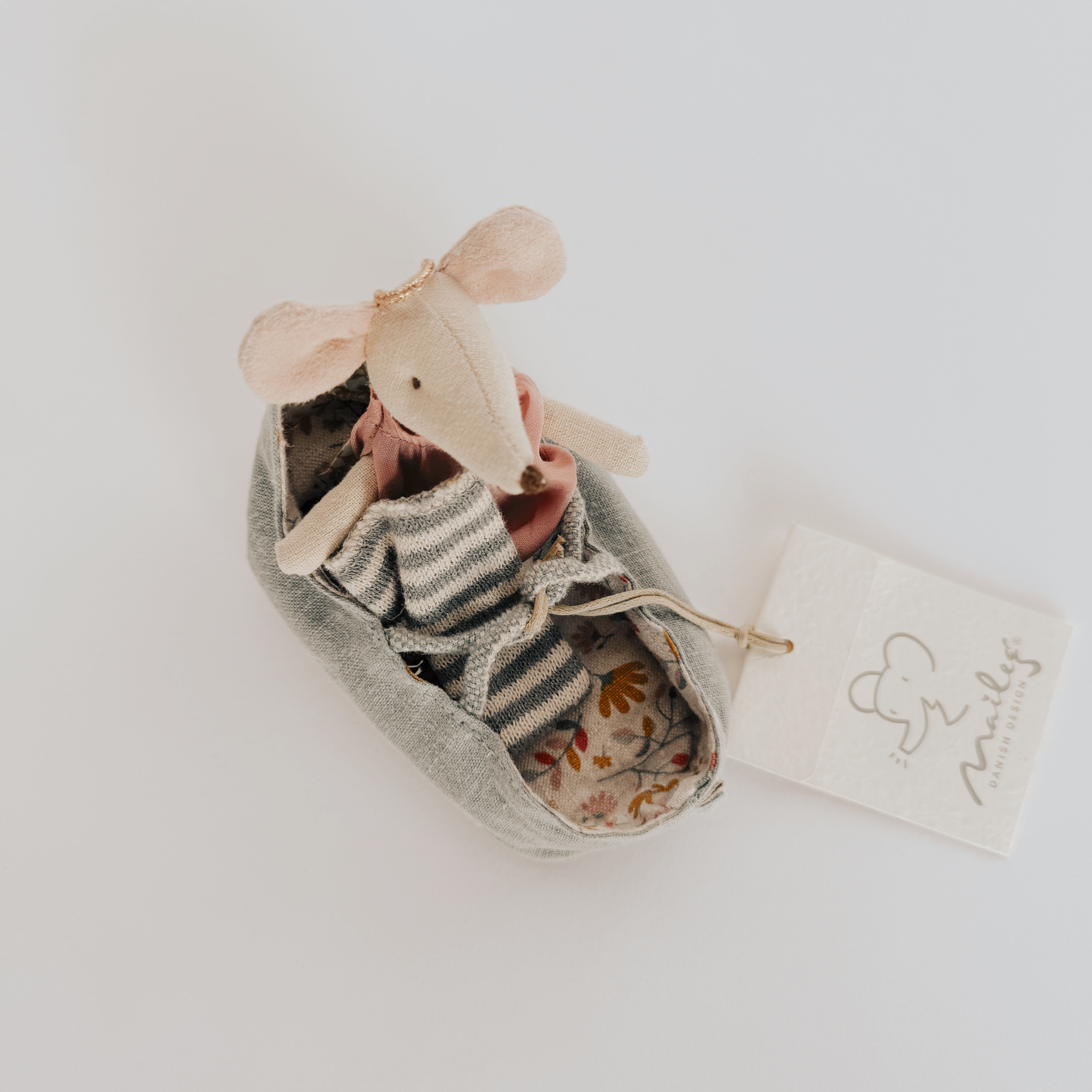 Maileg - Carry Cot with Angel Mouse by Grace & Company: angel mouse in striped outfit sits in fabric cot with branded tag.