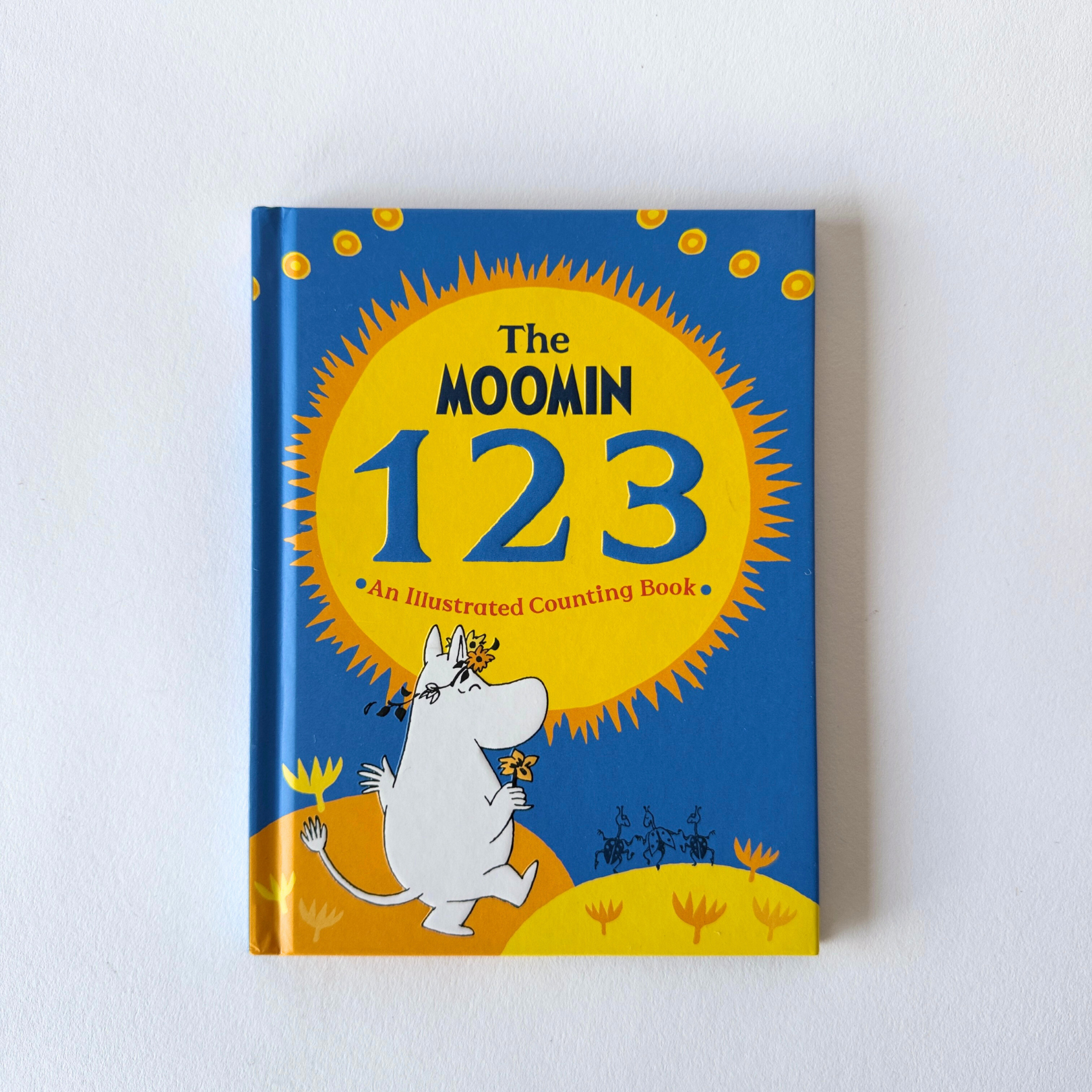 A blue childrens book, Moomin Book Beginner Series by Grace & Company, features a Moomin character on the cover.