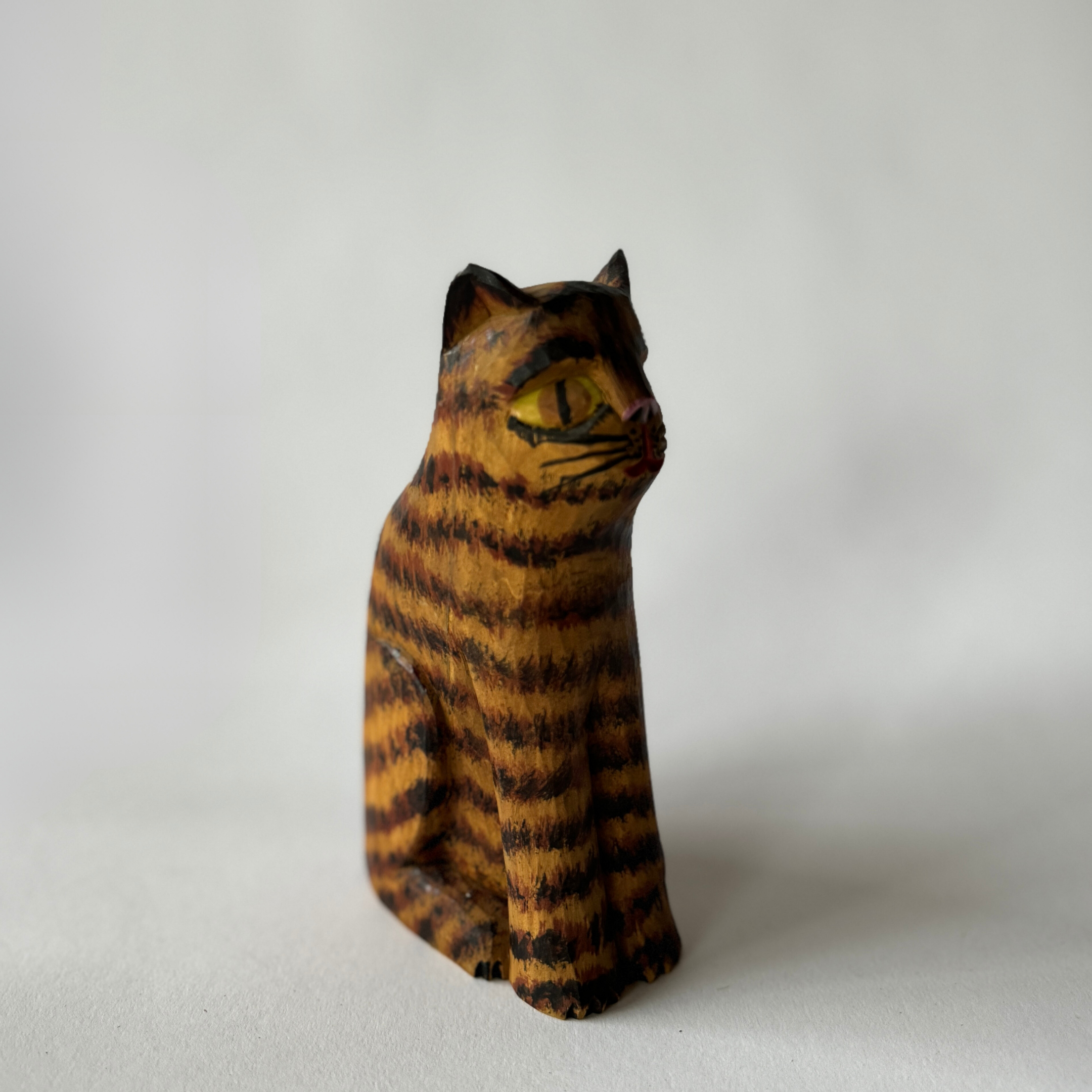 The Dom Sztuki wooden cat figurine by Grace & Company ltd features orange and black stripes on a white background.