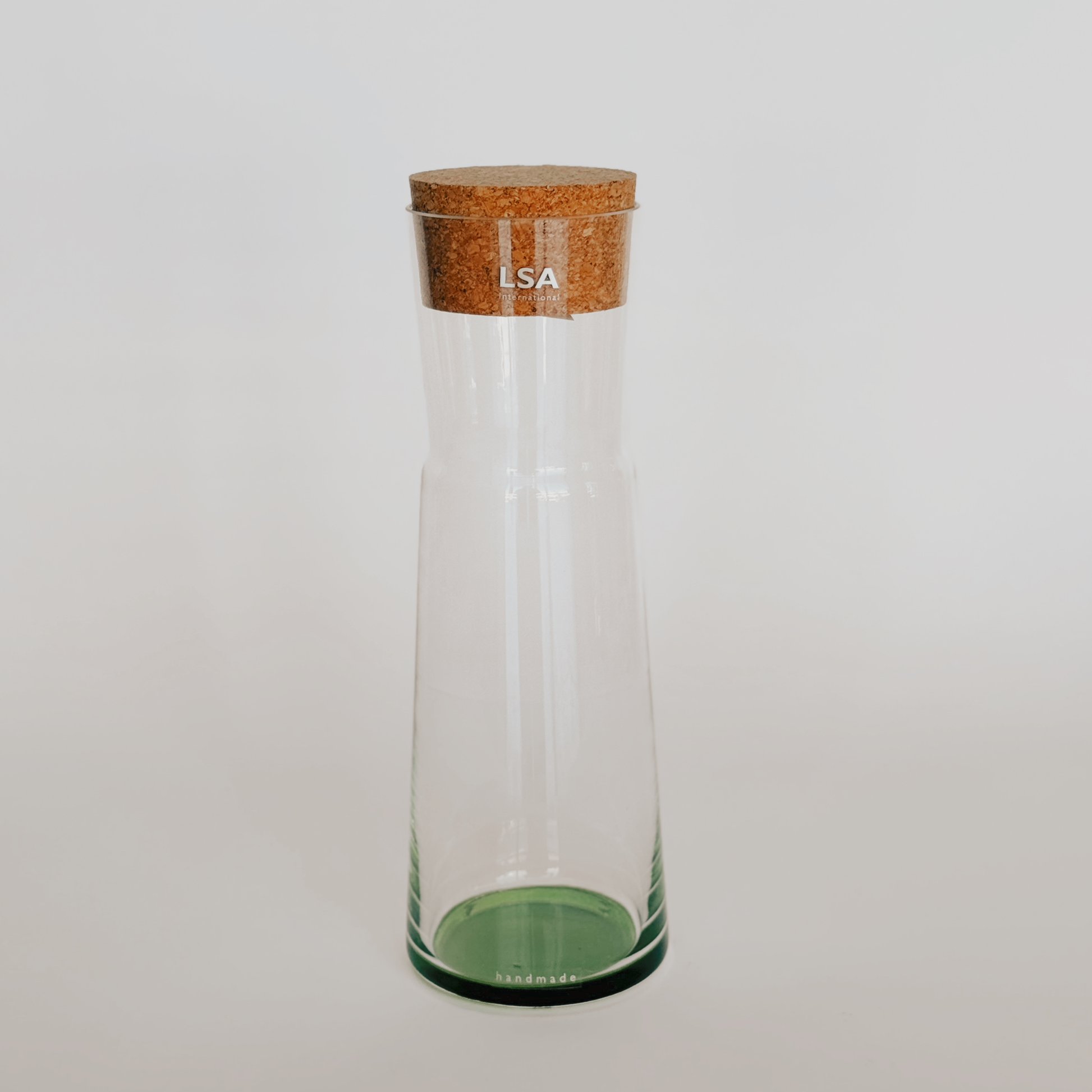 LSA - Coro Carafe - Leaf by Grace & Company, clear glass with cork lid, upright on a light background.