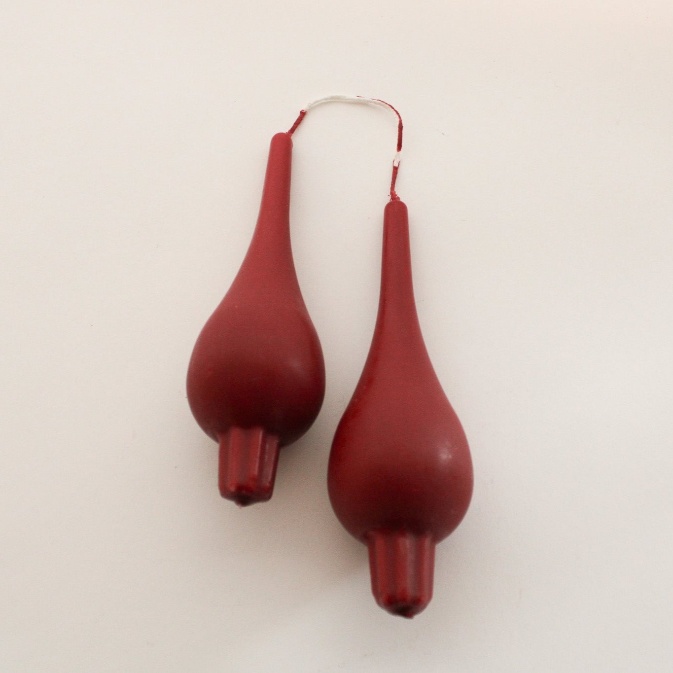 The Grace & Company ltd Danish Candle Drop Pair features two brown, teardrop shapes connected by a thin wire.