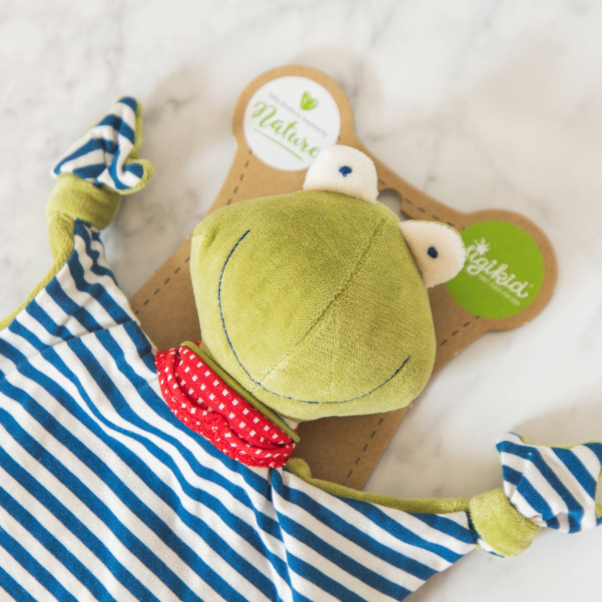 Grace & Company Organic Toy Blankie: plush frog with red scarf and blue-white stripes, shown in packaging.