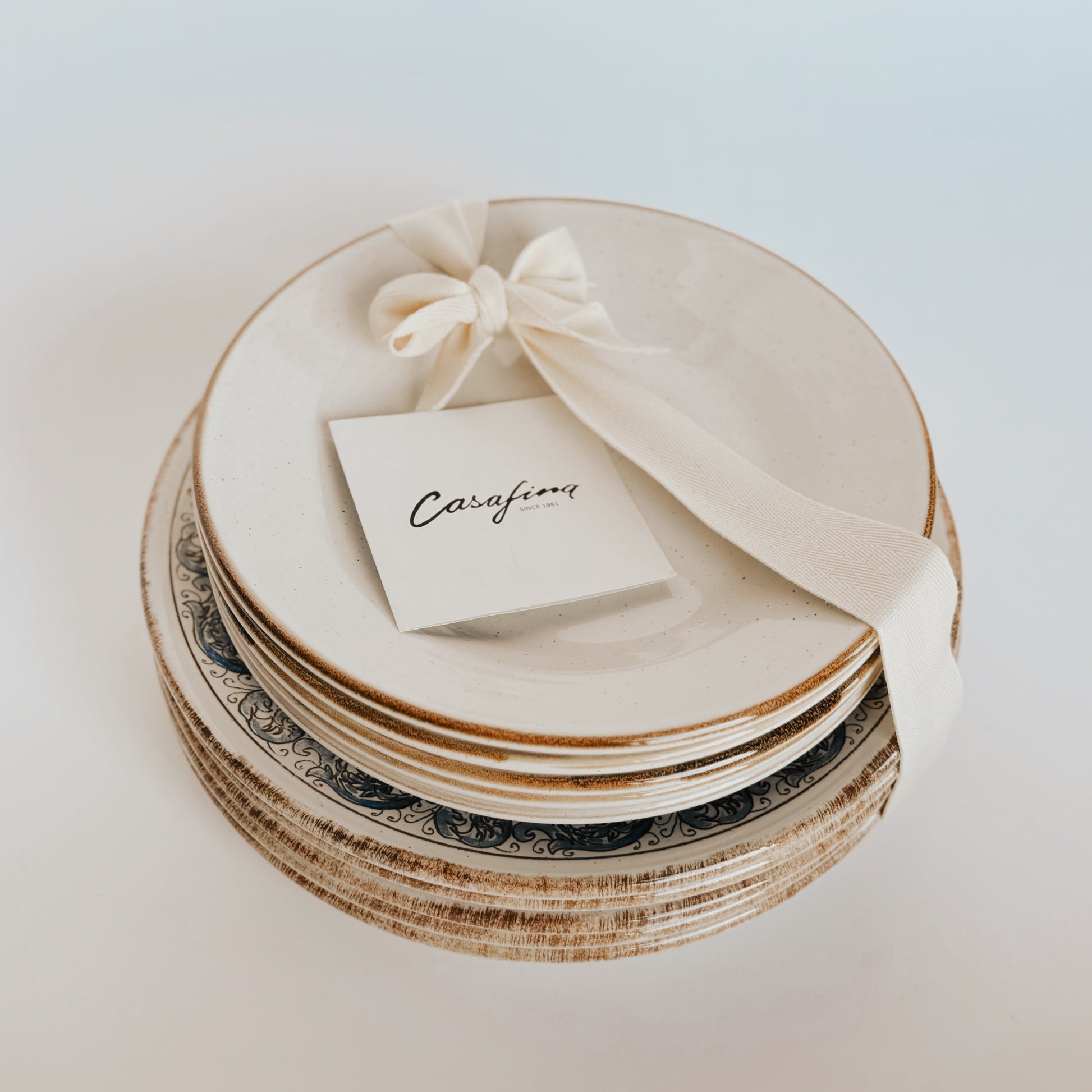 Sardegna Dinner Set by Costa Nova, topped with a white ribbon and Grace & Company card.