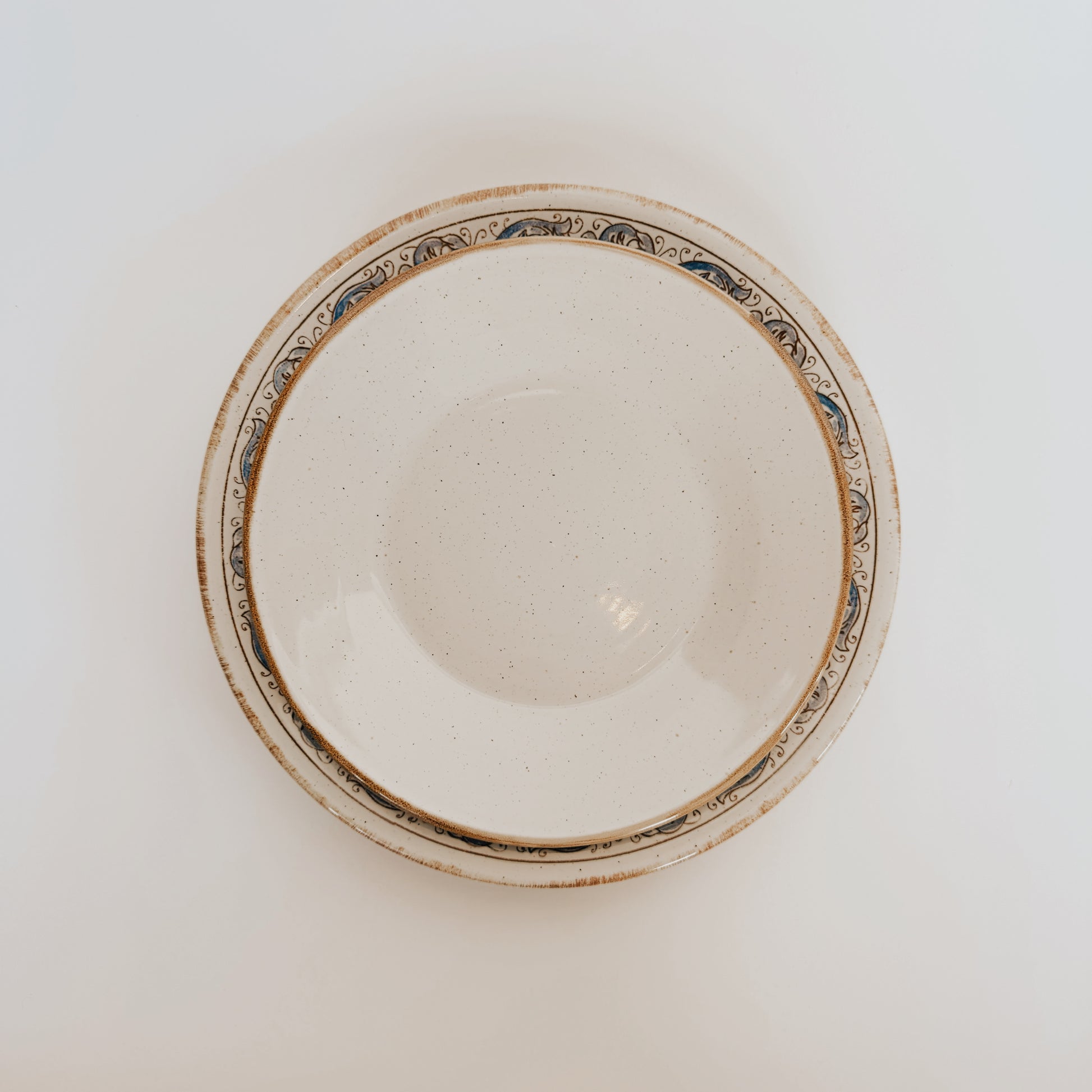 The Sardegna Dinner Set by Costa Nova, from Grace & Company, shows a patterned bowl stacked in a matching plate, top view.