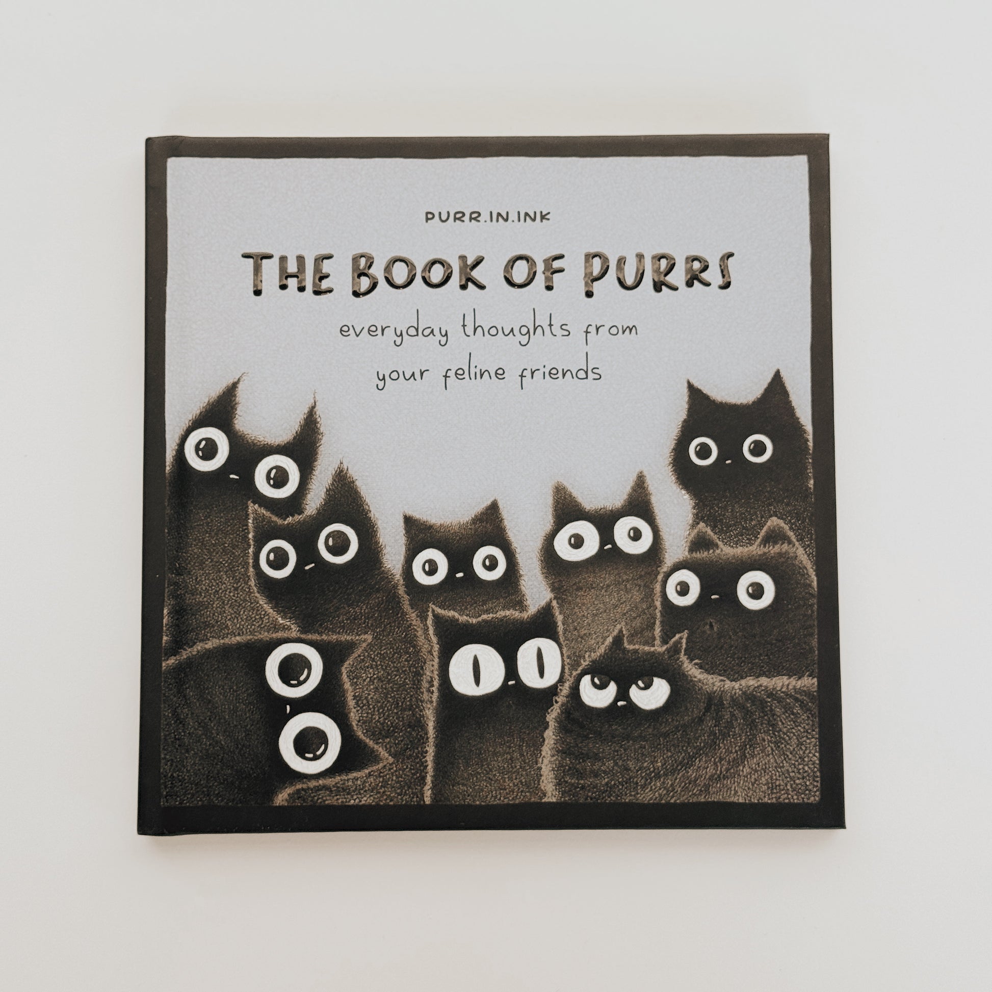 The Book of Purrs by Grace & Company ltd features illustrated black cats and everyday thoughts from your feline friends.
