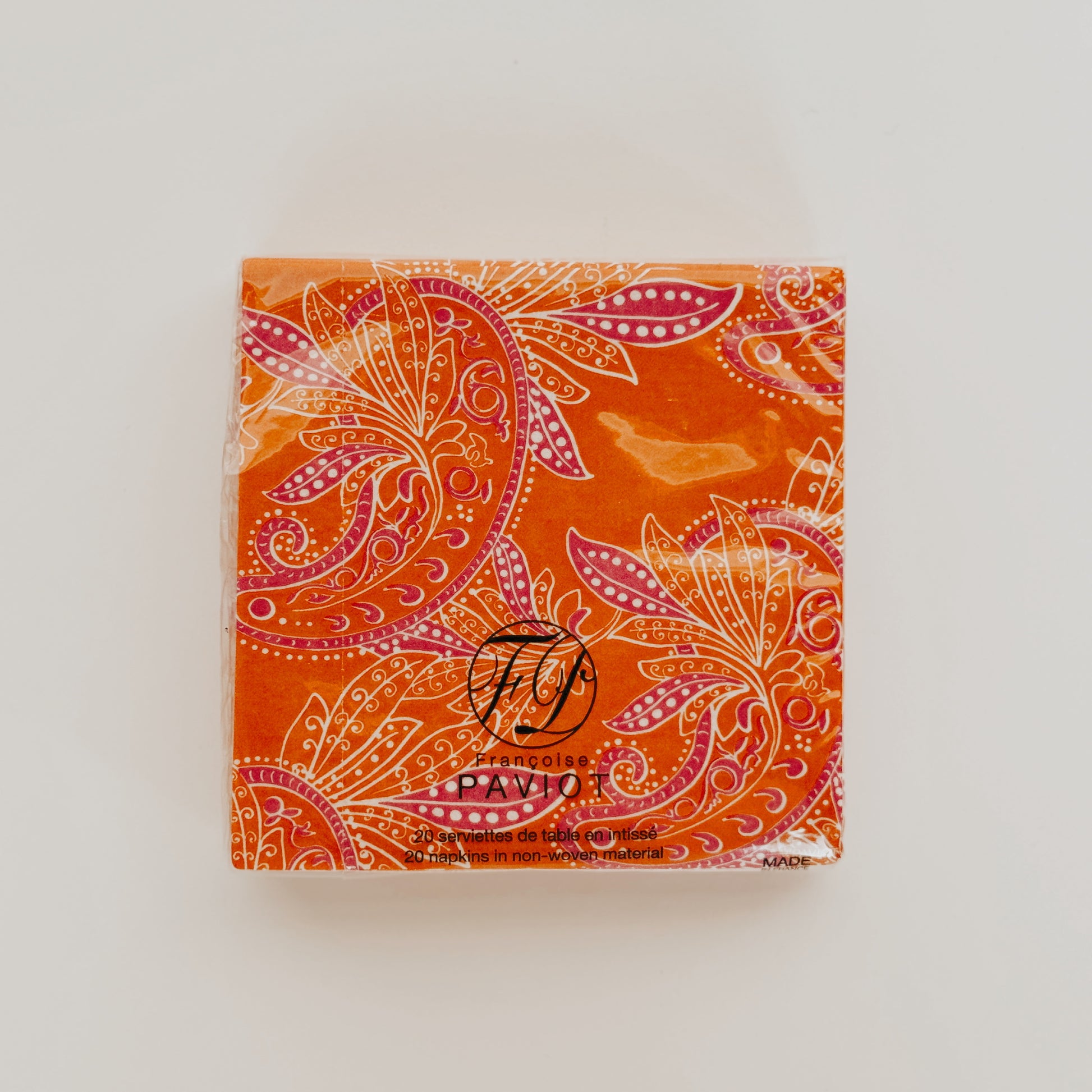 Square orange Paviot - Indi Napkins by Grace & Company with pink and white paisley designs and black front text.