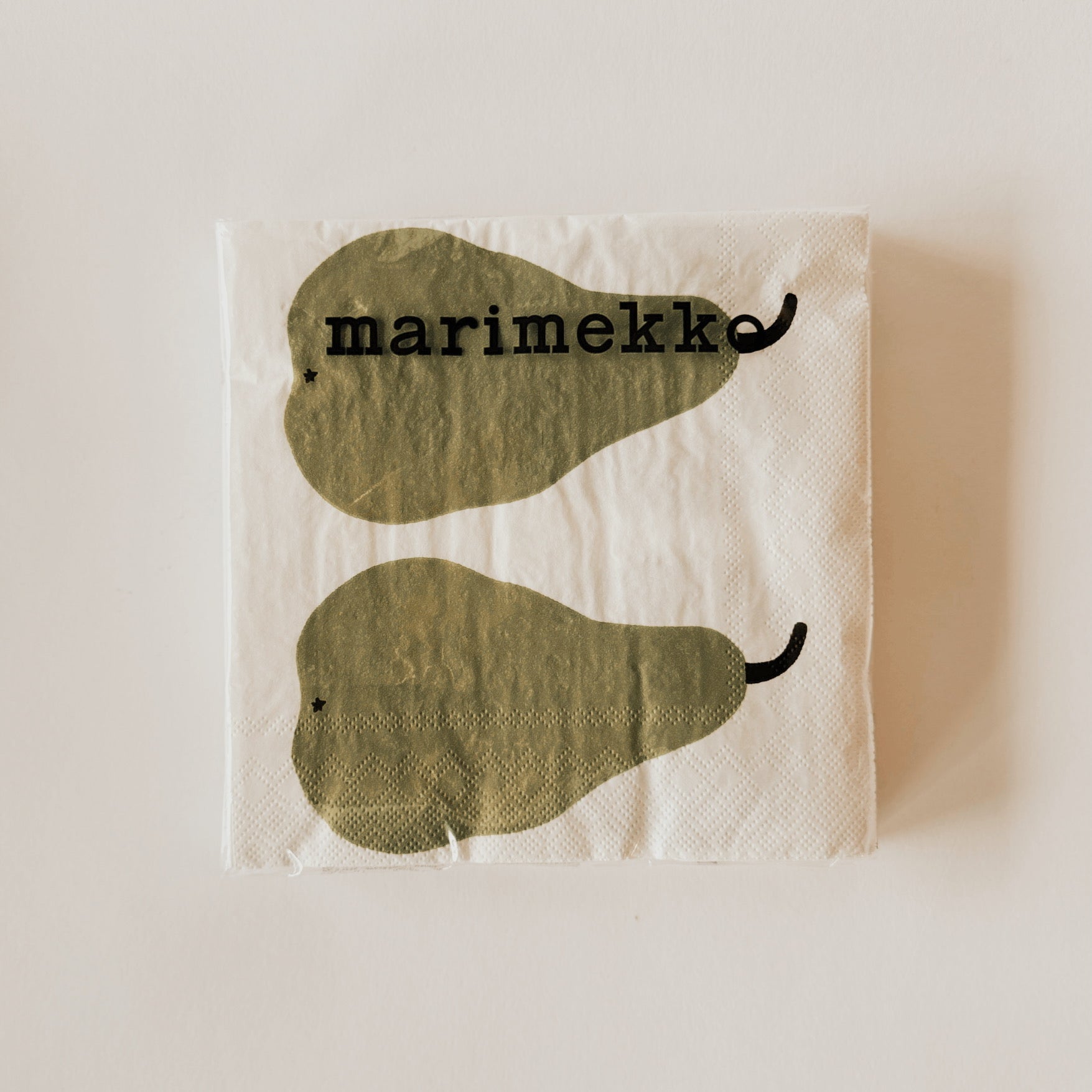 The Marimekko - Paaryna Napkin by Grace & Company features two green pears on white with marimekko text above.