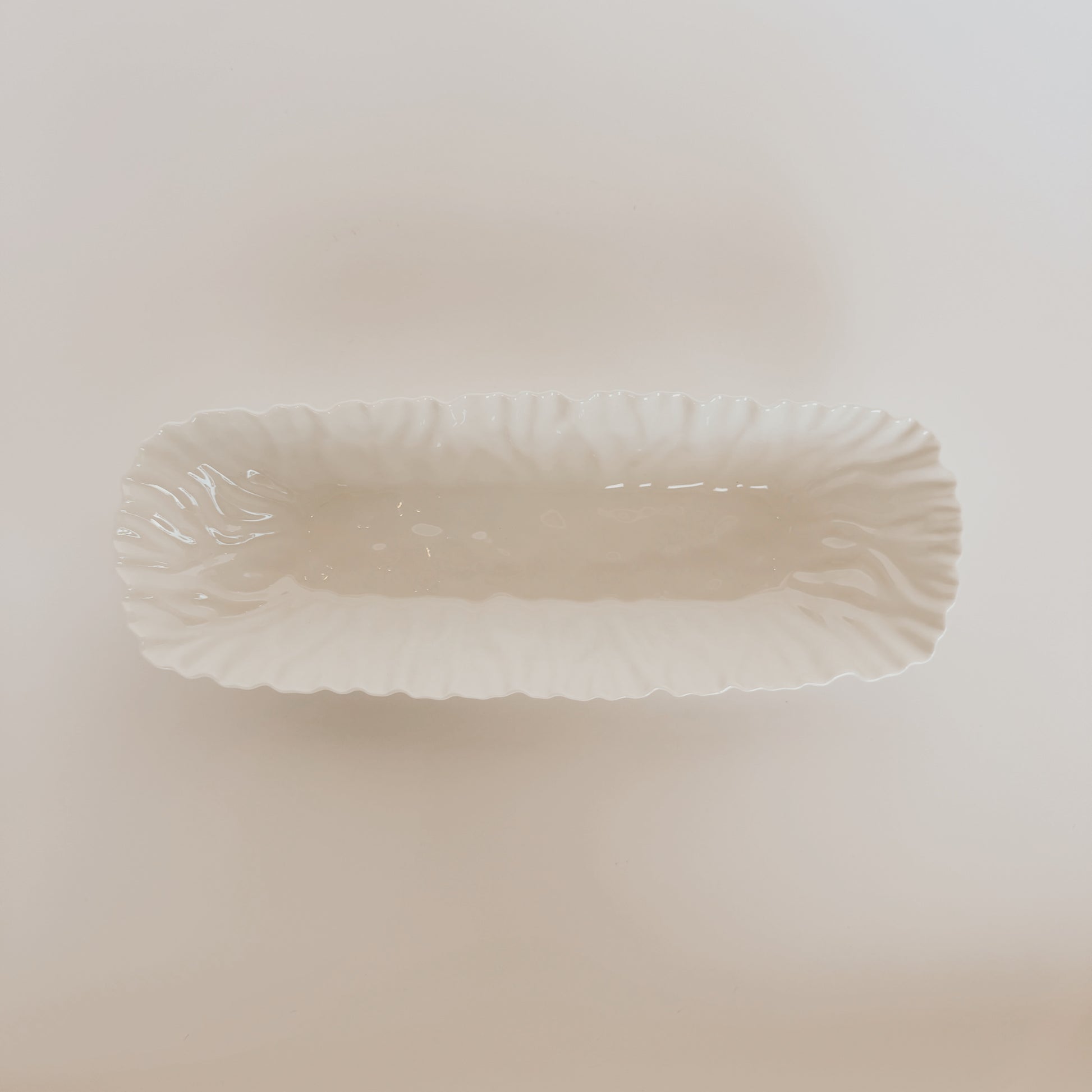 Mascali Bianca Serve Collection by Grace and Company Ltd: rectangular white ceramic dish with ruffled edges, top view.