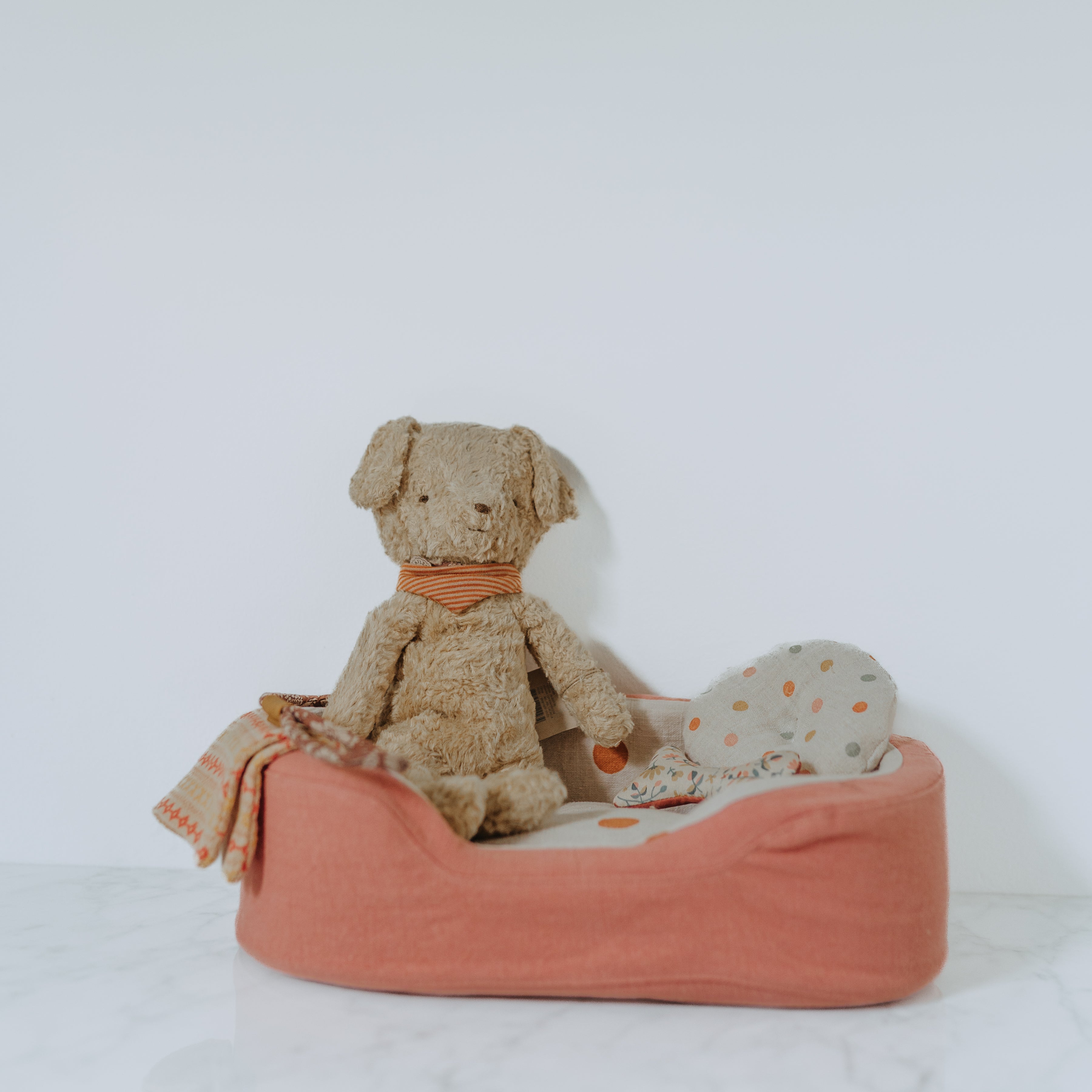 The Grace & Company Maileg - My First Puppy Bundle features a brown stuffed dog with accessories in a pink pet bed.