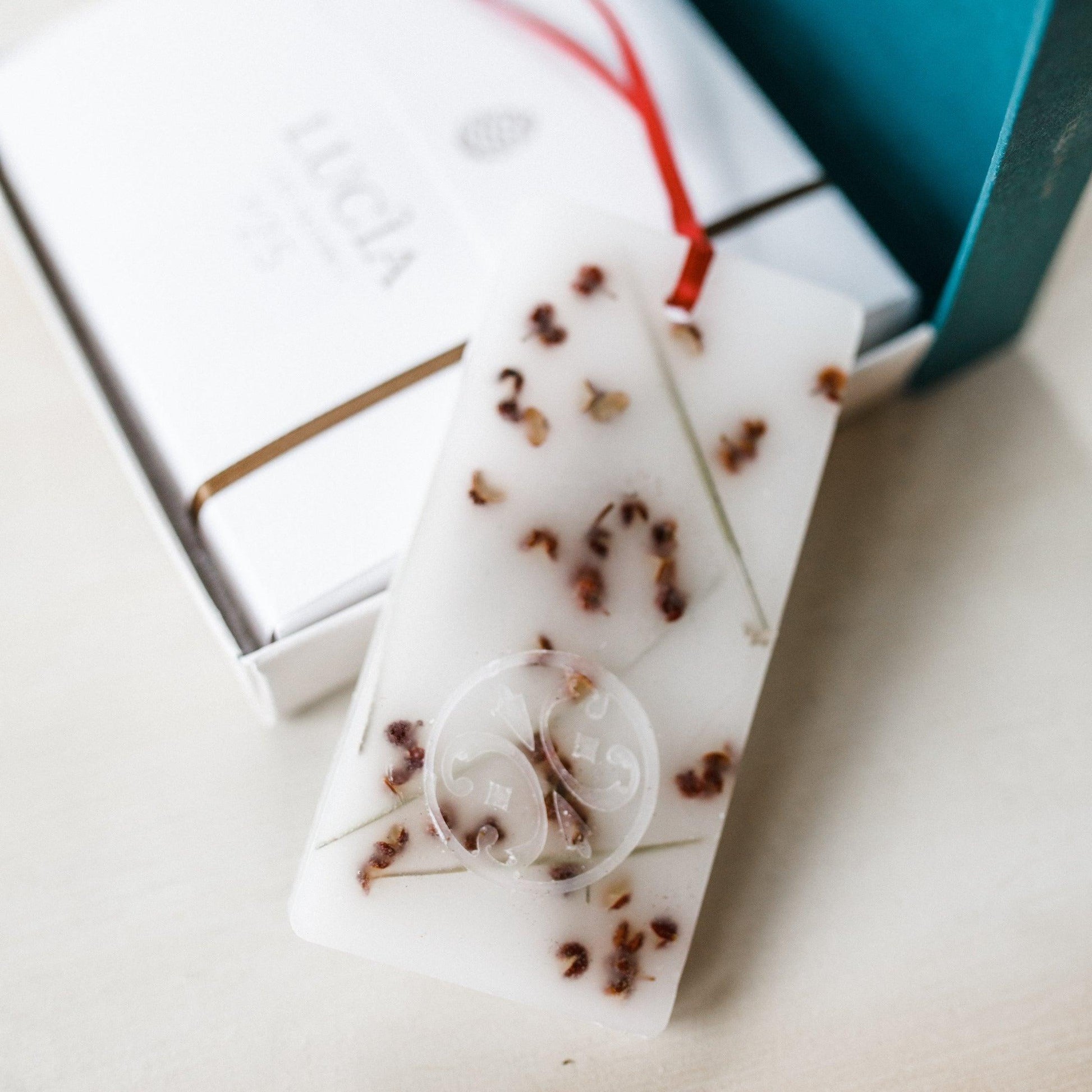 The Lucia Les Saisons Douglas Pine Scented Wax Tablet by Grace & Company Ltd comes gift-boxed with dried flowers and ribbon.