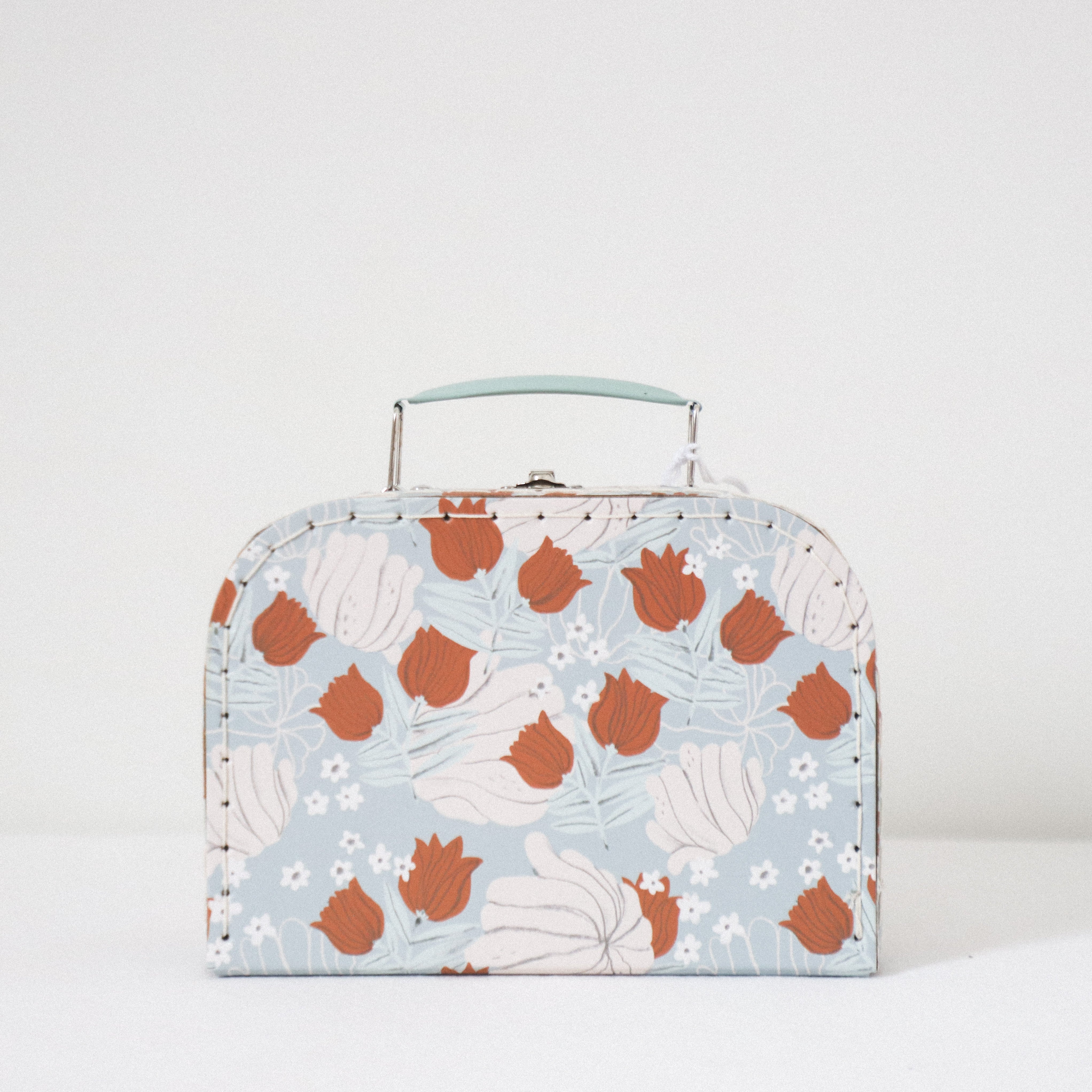 The Rates suitcase by Grace & Company ltd features a pastel blue base with white and rust floral patterns.