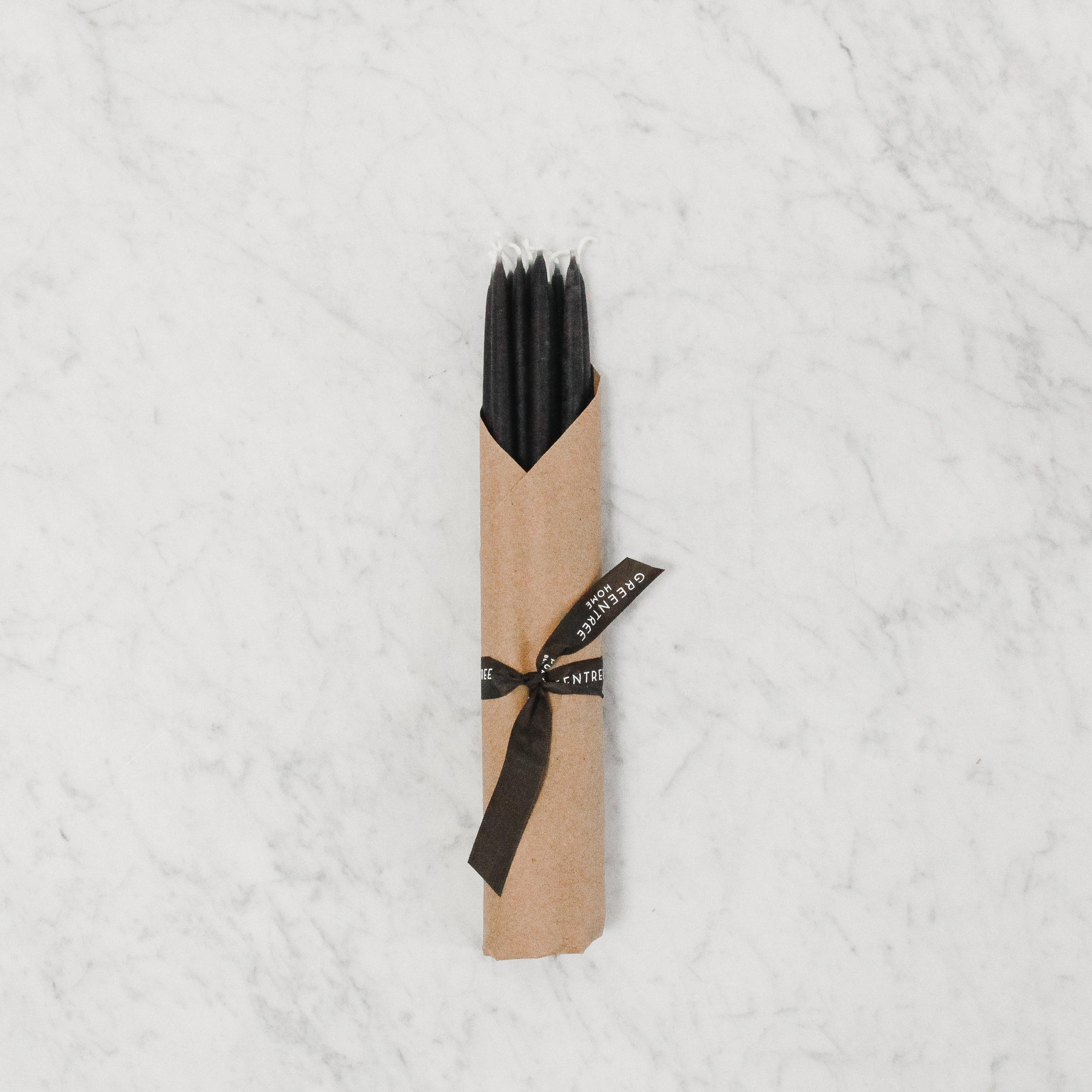 Four Green Tree 100% Beeswax Event Candles by Grace & Company on a white marble surface, wrapped in brown paper.