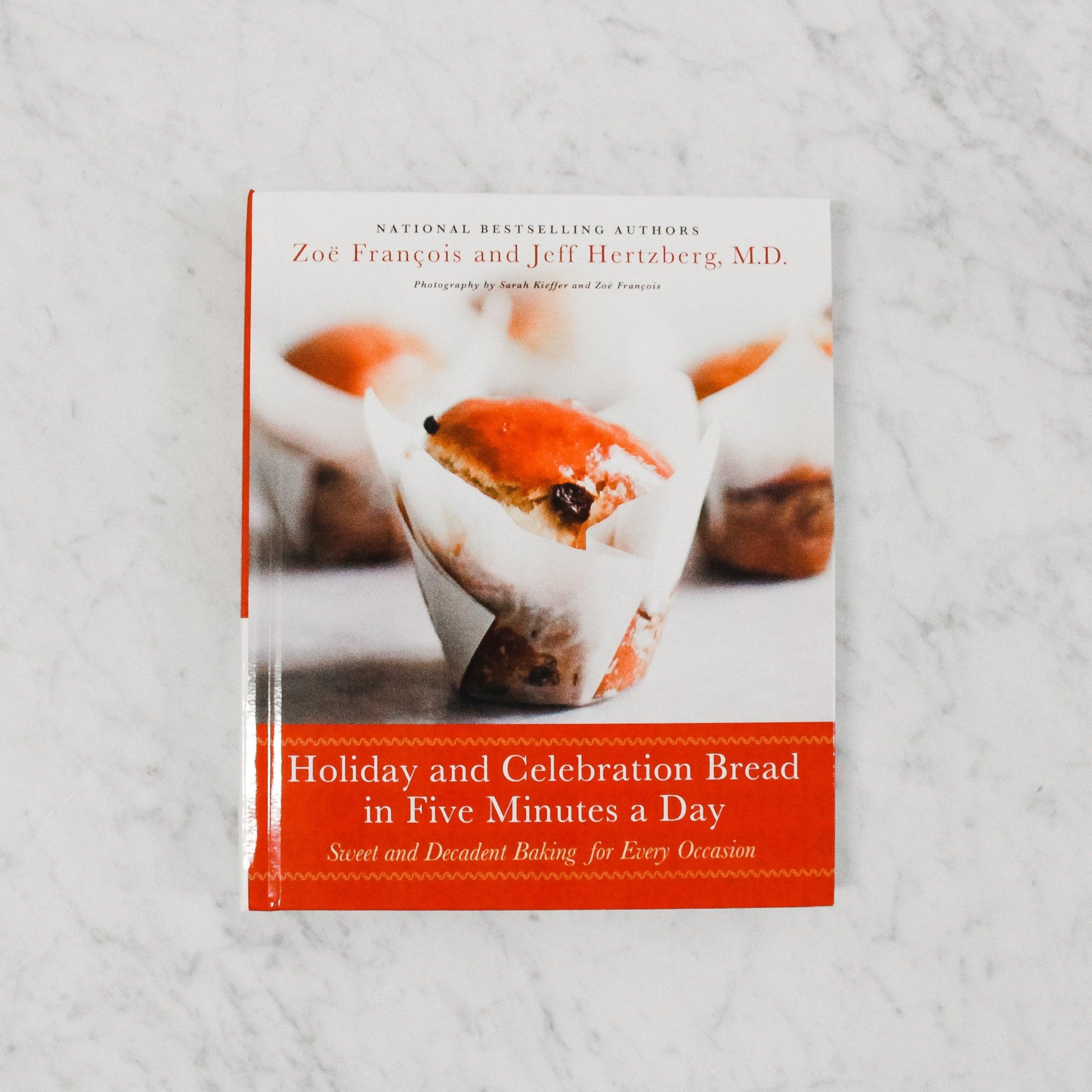 Grace & Company’s Holiday and Celebration Bread in Five Minutes a Day cookbook on a white marble surface.