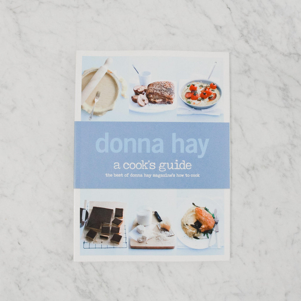 front cover of donna hay's a cook's guide. features 6 different dishes (3 on top, 3 on bottom) and a light blue background