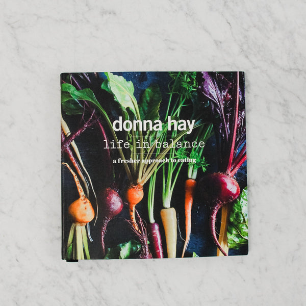 cover of donna hay's life in balance. cover features an assortment of harvested root vegetables against a black background