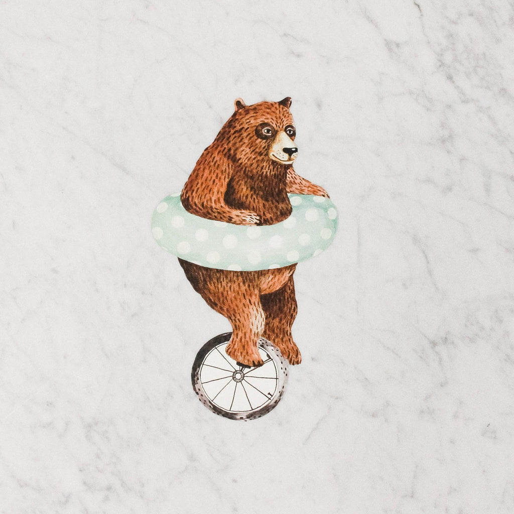 hester & cook table accent featuring a brown bear with an inner tube riding a unicycle