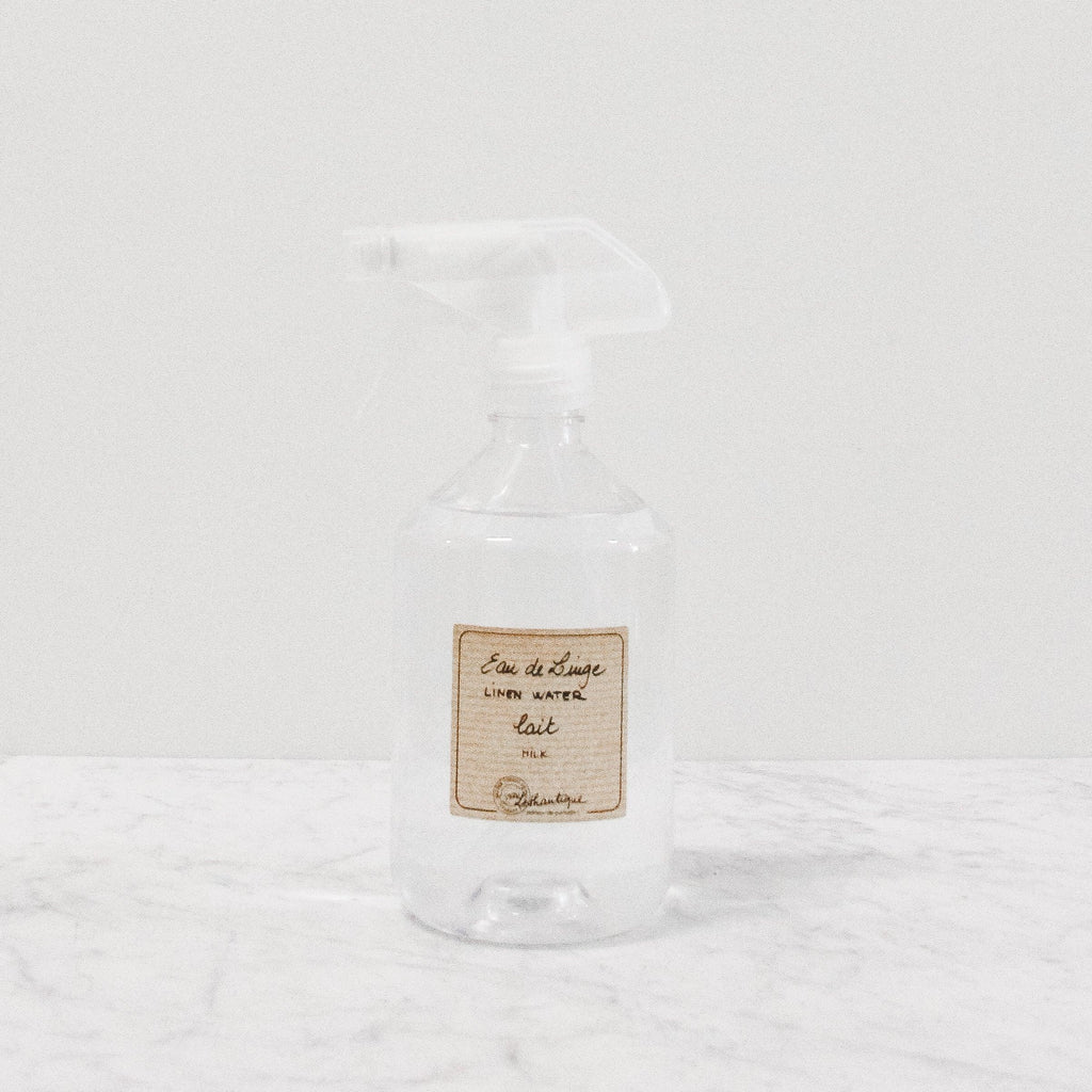 clear plastic spray bottle containing lothantique's linen water spray scented in milk