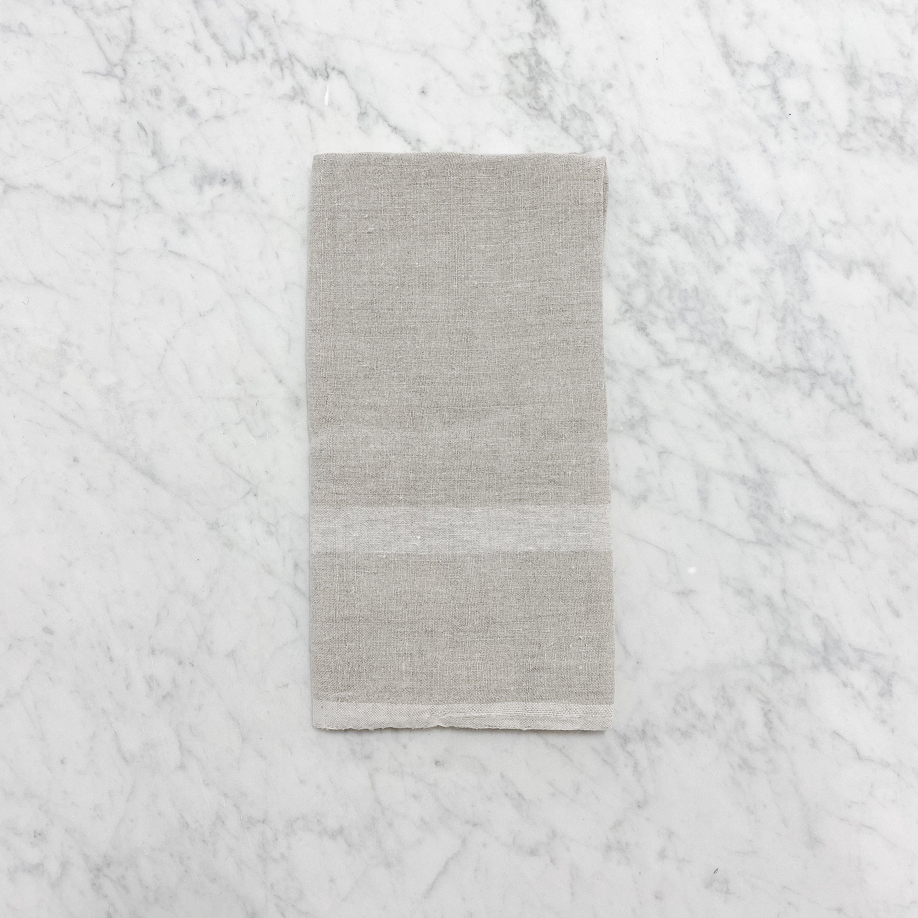 A folded Modern Kitchen Towel by Grace & Company on a light gray marble surface.