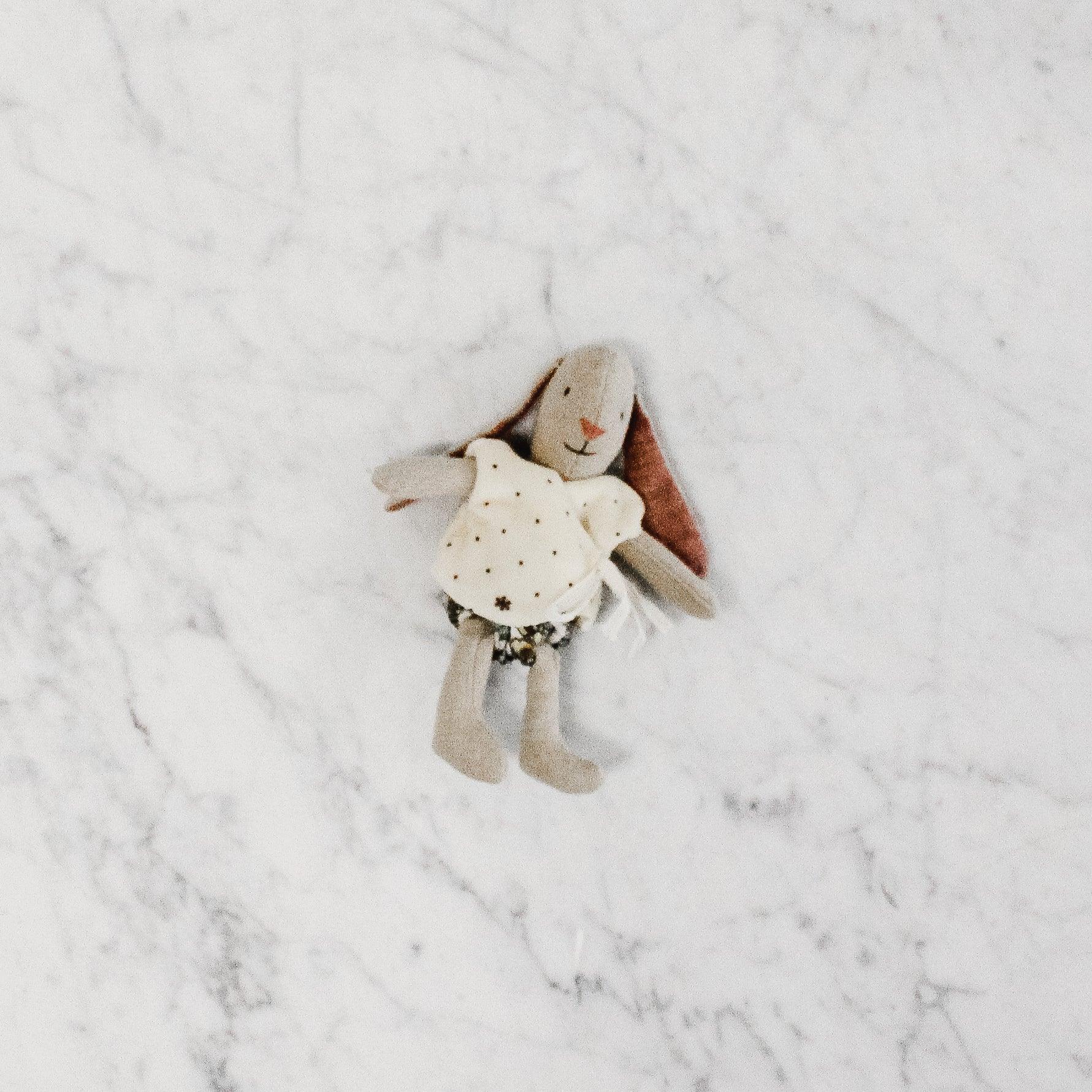 The Maileg - My Rabbit by Grace & Company ltd wears a star-print dress and rests on a white marble surface.