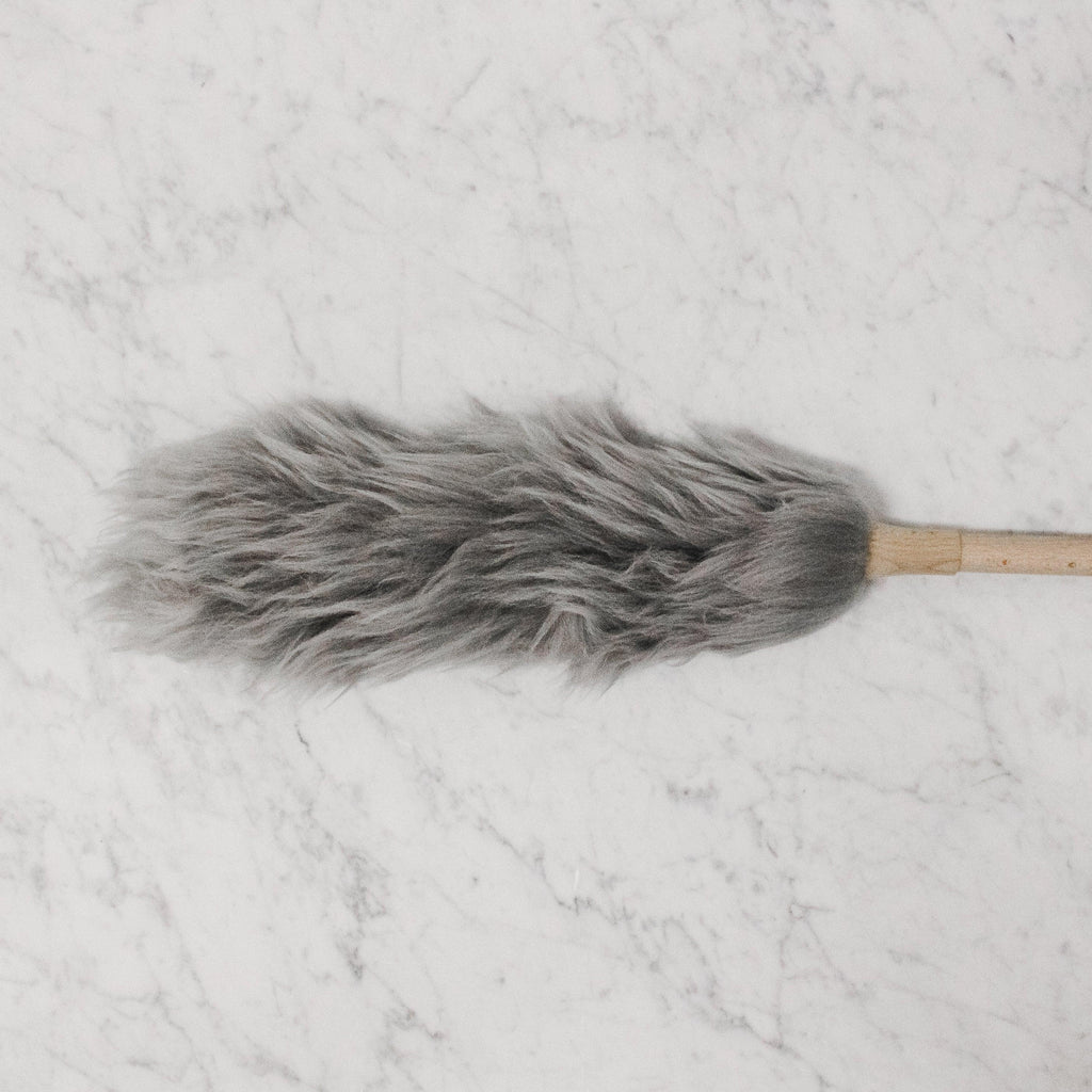 Natural / Grey coloured wool duster with a wood handle.