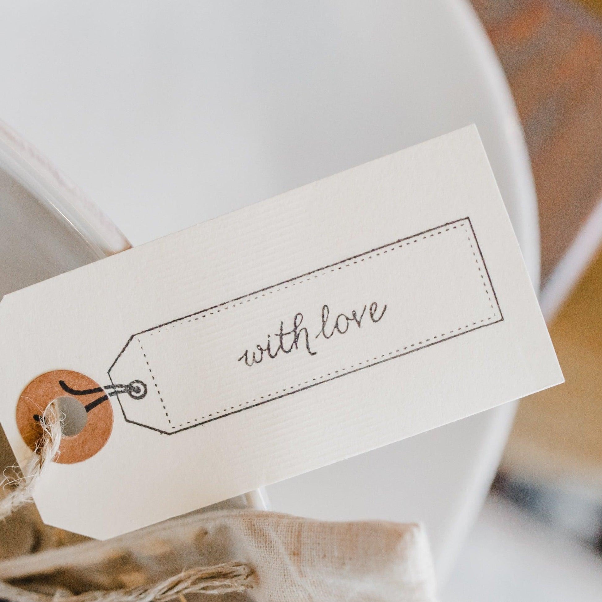 A Grace & Company Gift Wrapping with a with love cursive tag on twine, wrapped around your special item.
