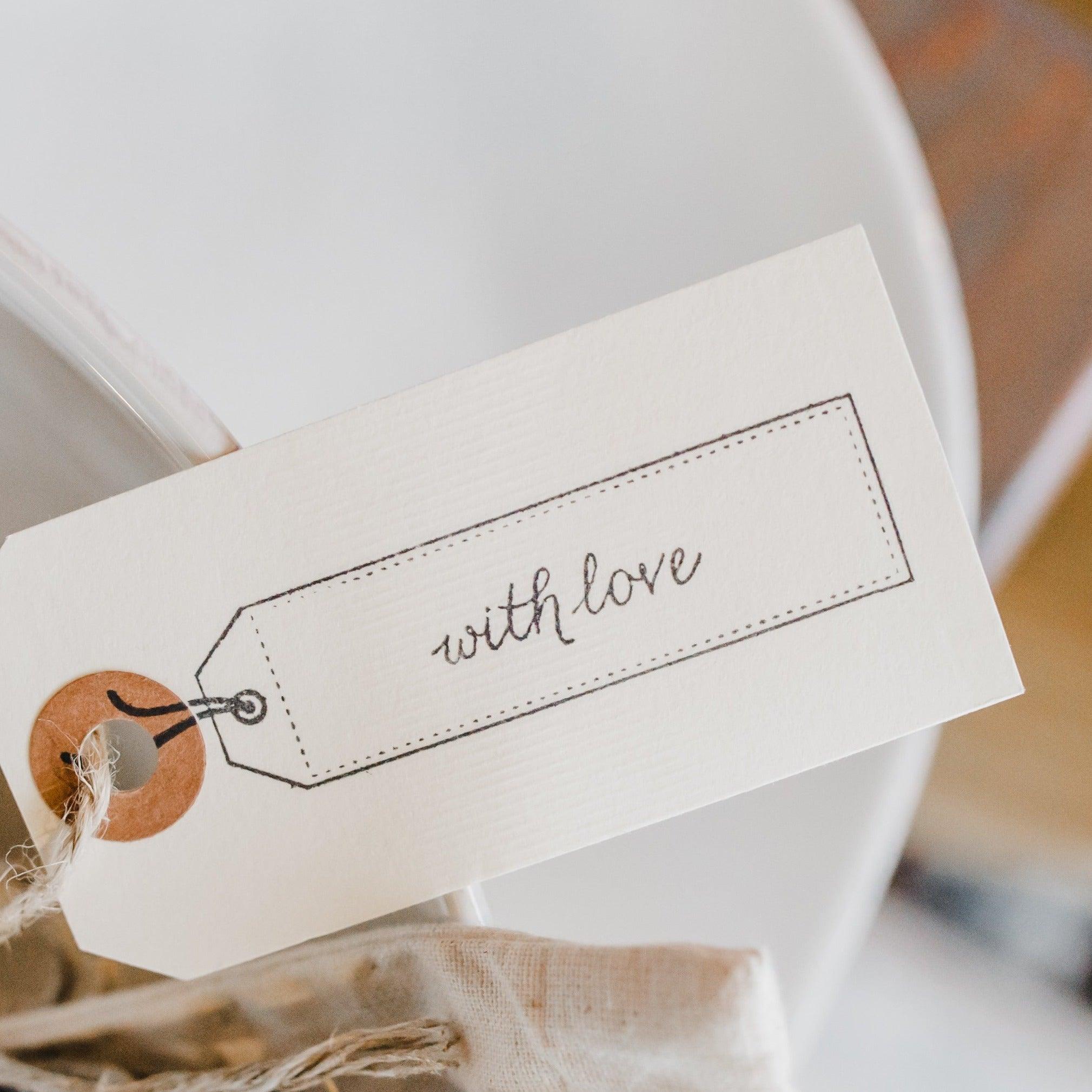 A Grace & Company Gift Wrapping with a with love cursive tag on twine, wrapped around your special item.