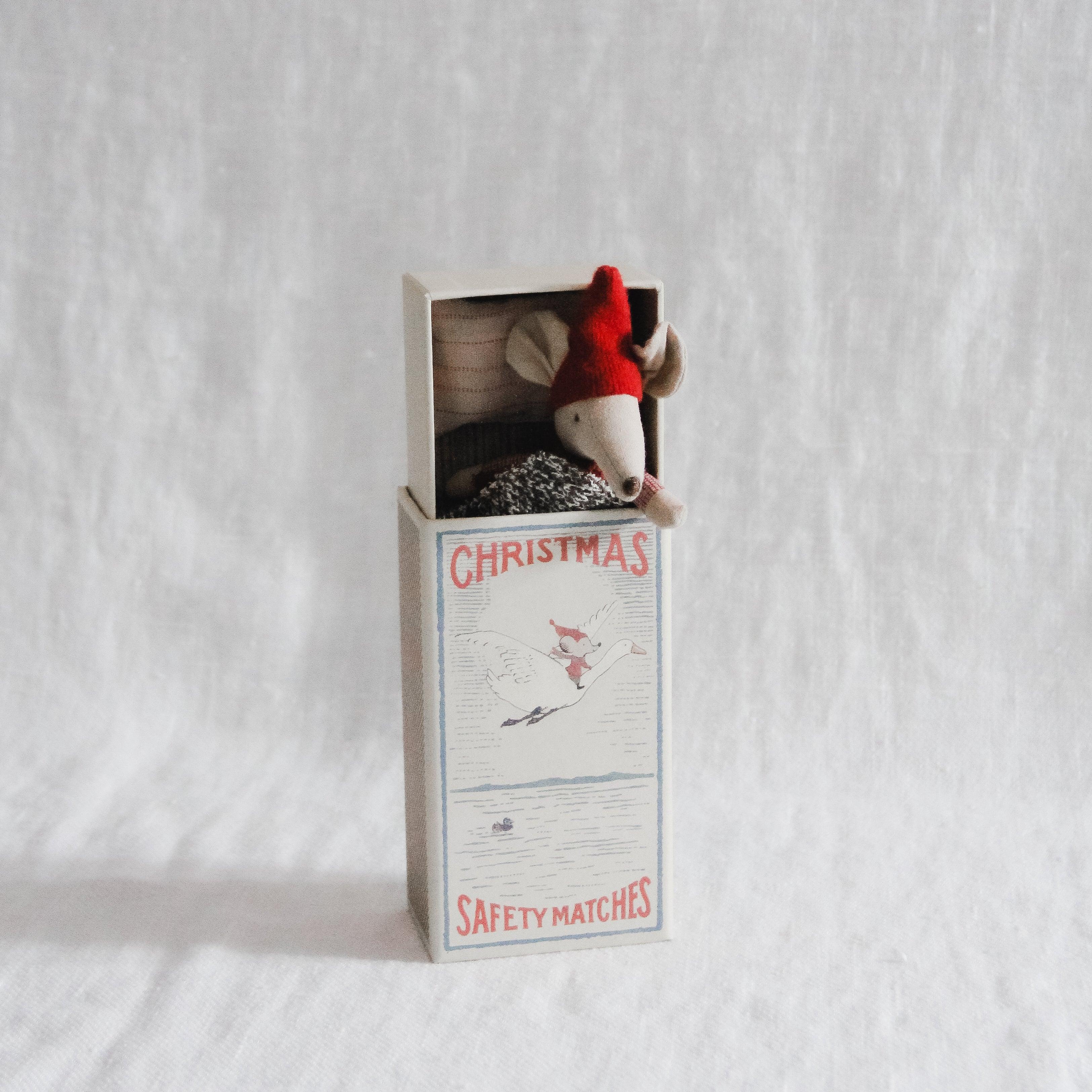 The Maileg Christmas Mouse in Matchbox - Big Brother by Grace & Company peeks out in a red hat.