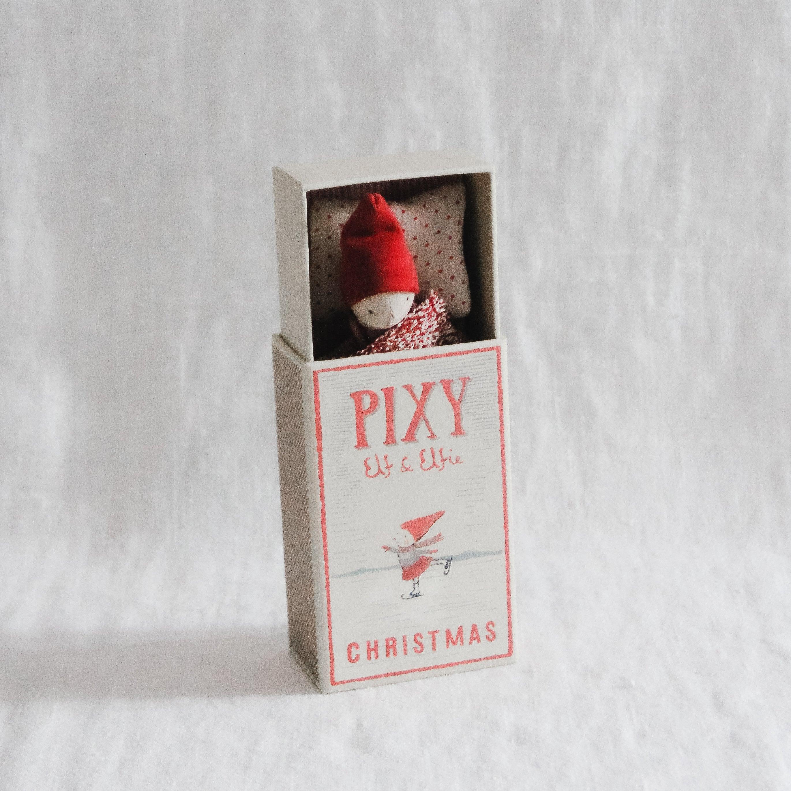Maileg - Pixy Elfie in a Box by Grace & Company: small elf doll in red hat tucked in matchbox on white background.