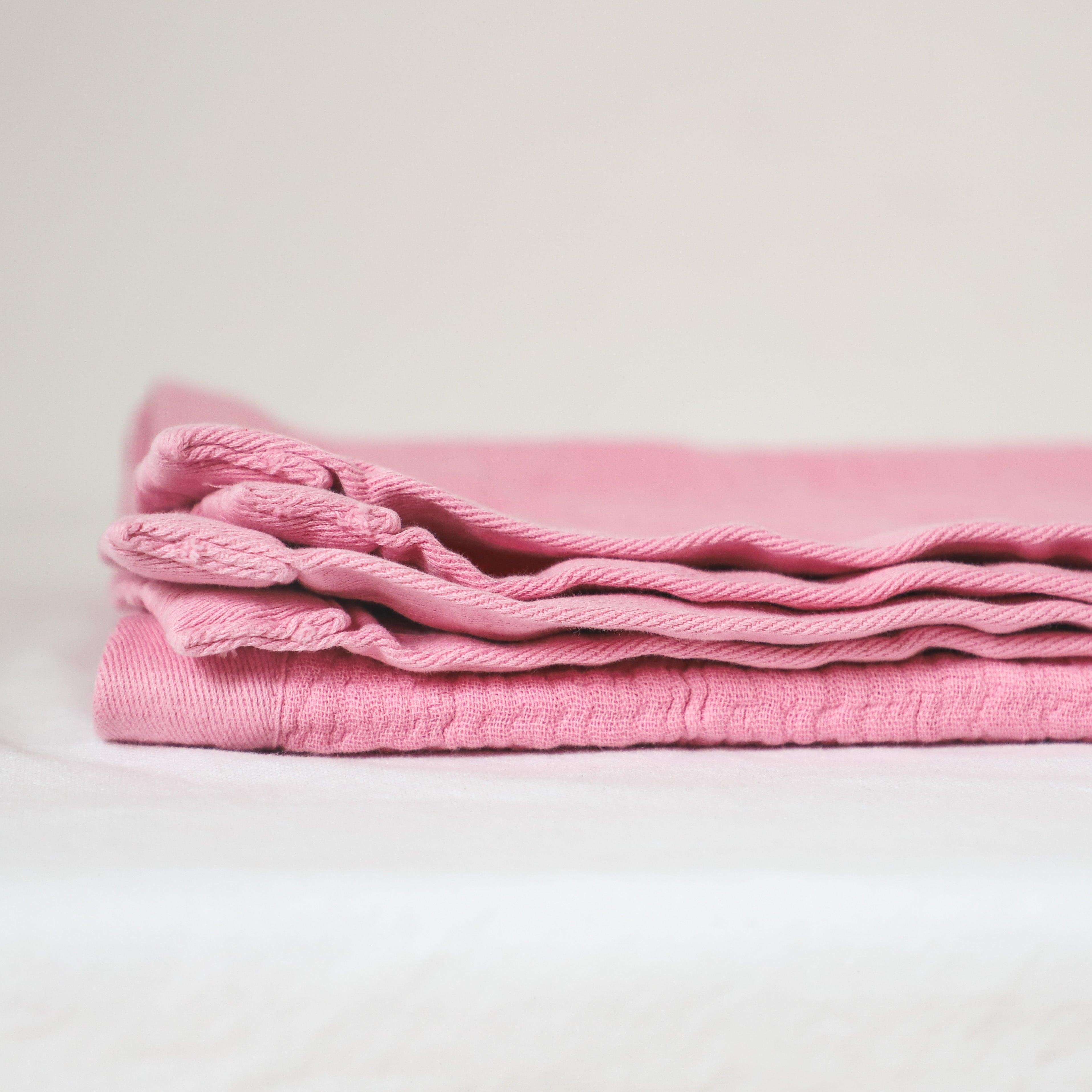 A neatly folded Linen Way - Porto Baby Blanket by Grace & Company ltd rests on a white surface, minimal background.