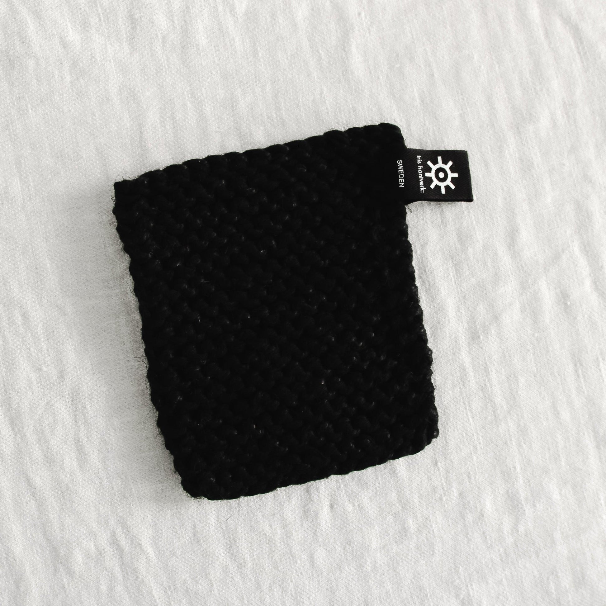 The Grace & Company Iris Hantverk Cotton/Linen Pot Holder rests on a white textured surface.