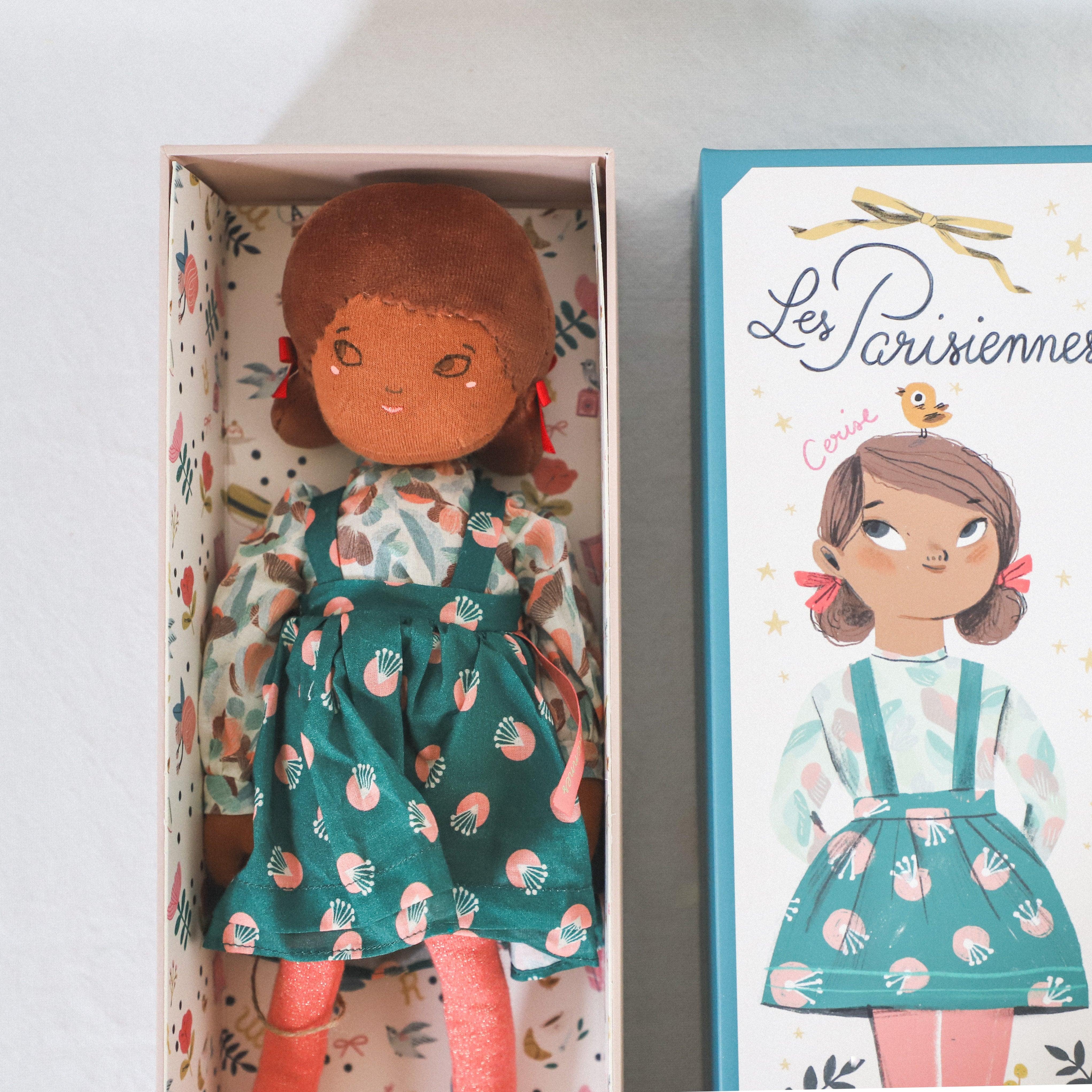 The Moulin Roty Les Parisiennes Cerise Doll by Grace & Company comes in a green dress with matching illustrated box.
