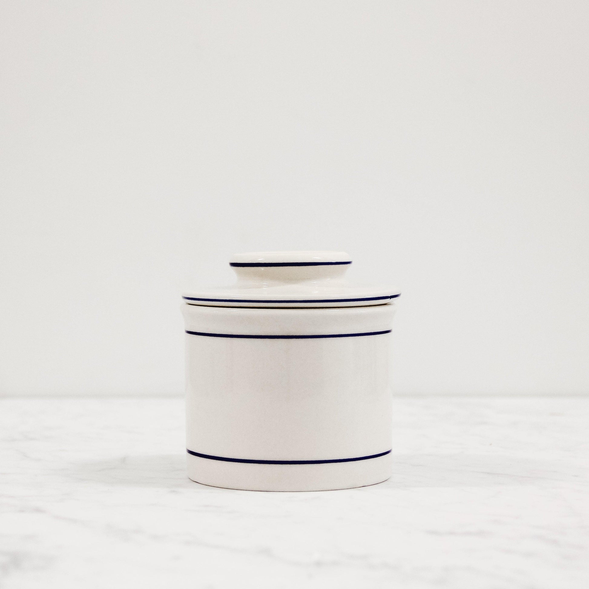 white ceramic butter crock with blue trim