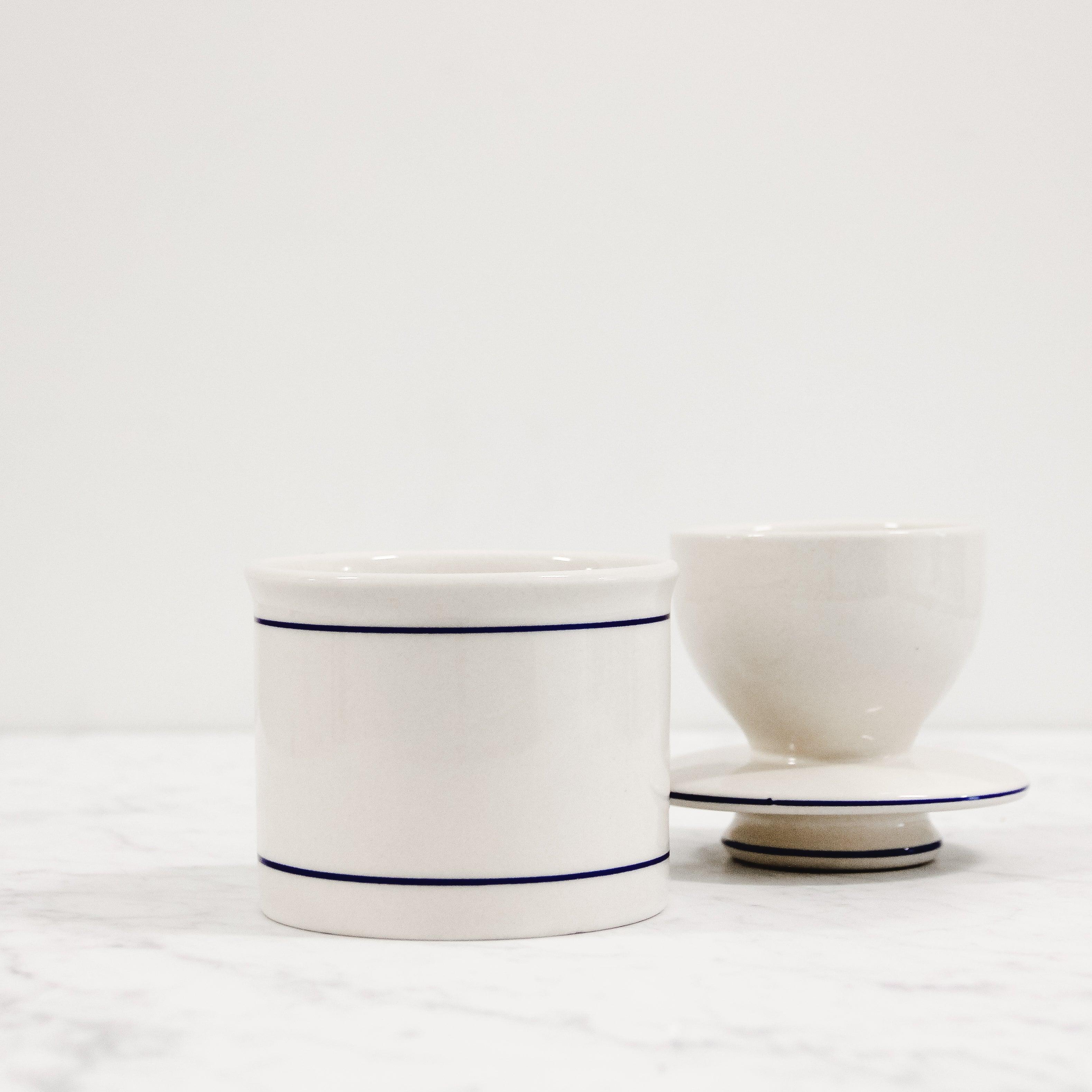 The Butter Keeper (Stoneware) by Grace & Company ltd sits on a white marble surface with a plain white background.