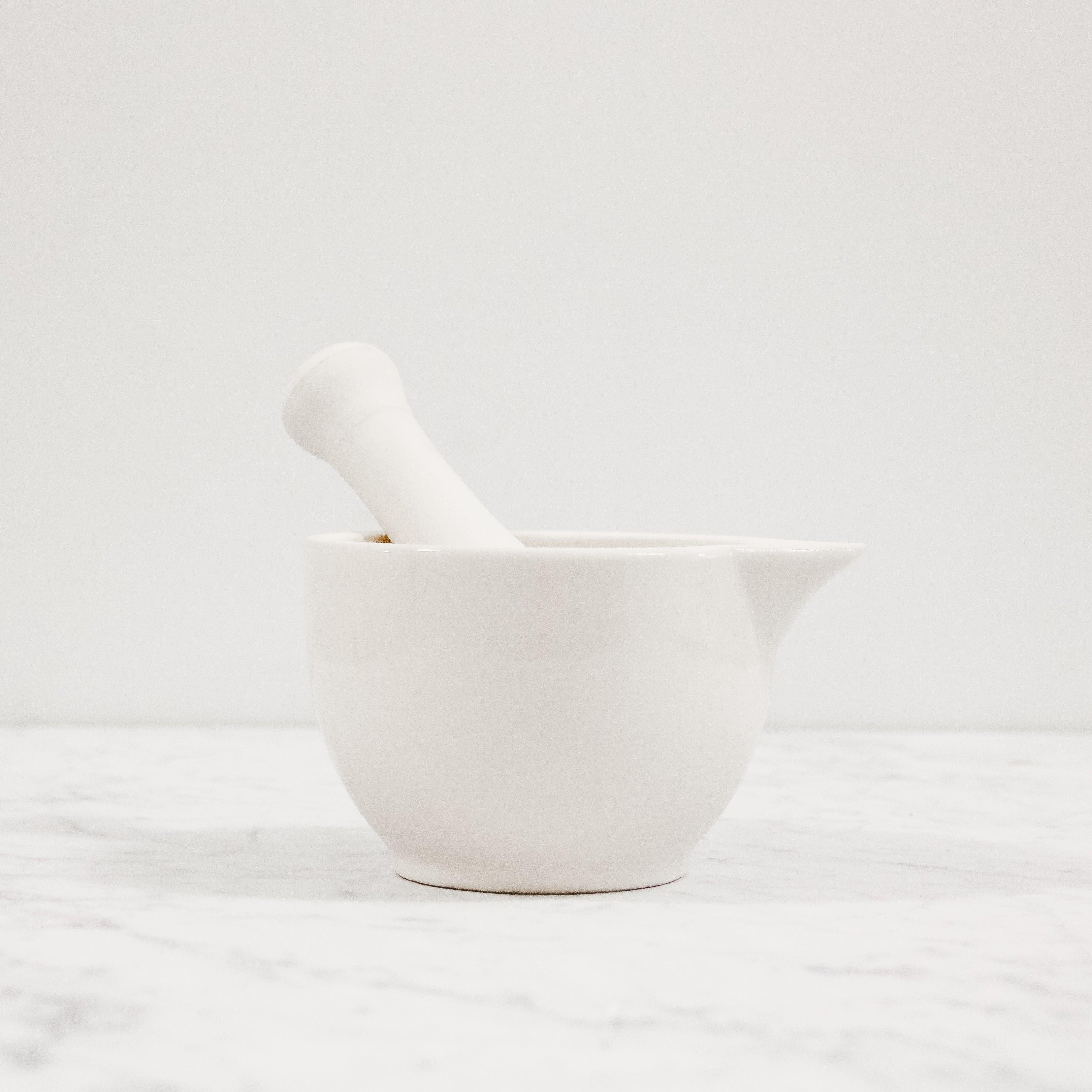 The Mason Cash Mortar and Pestle by Grace & Company Ltd on white marble with a plain white background.