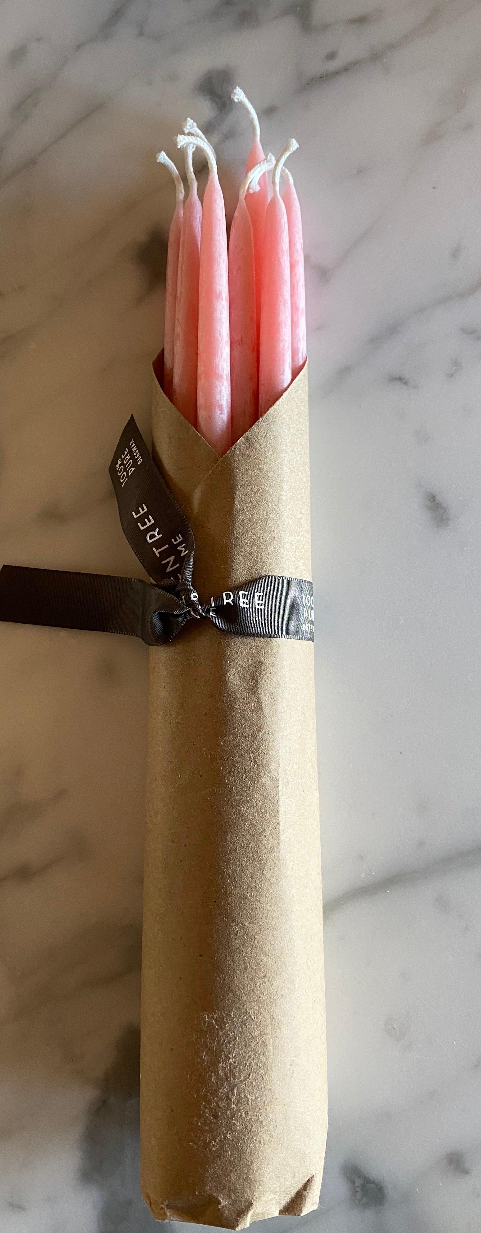 Five Green Tree 100% Beeswax Event Candles by Grace & Company ltd, wrapped in brown paper on a marble surface.