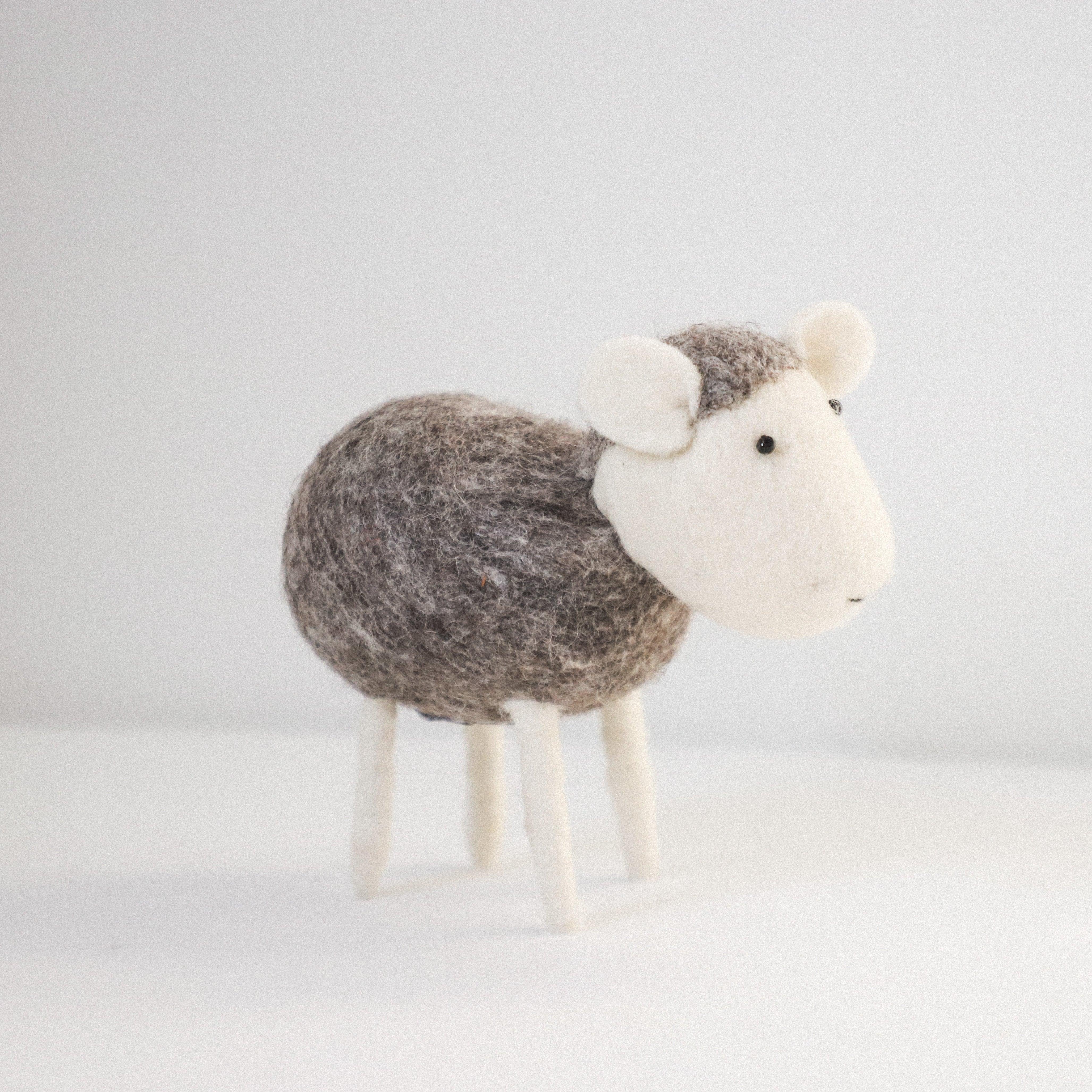 The Scandi - Grey Sheep by Grace & Company is a felted wool figurine with a gray body and white head, ears, and legs.
