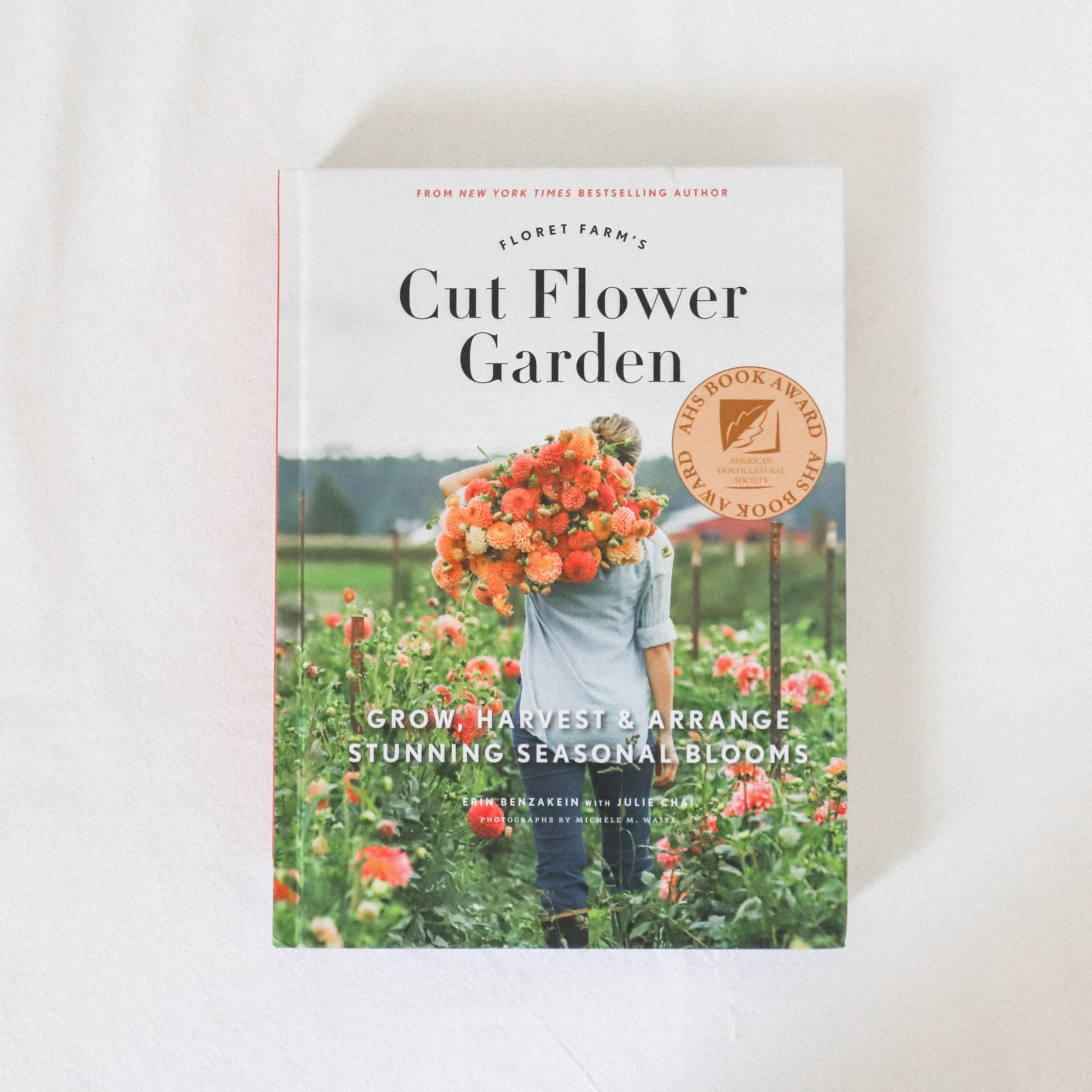 Floret Farm Garden Books by Grace & Company on a white surface, showing a person with a bouquet in a field.