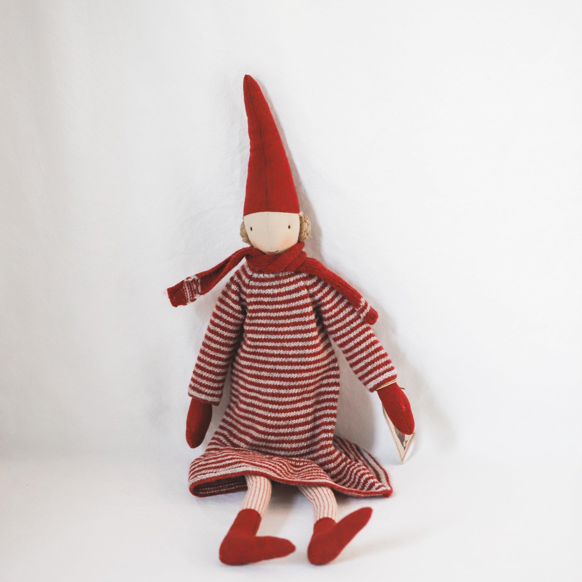 The Maileg - Pixy Collection Christmas Edition doll by Grace & Company sits in red and white clothes on a white background.