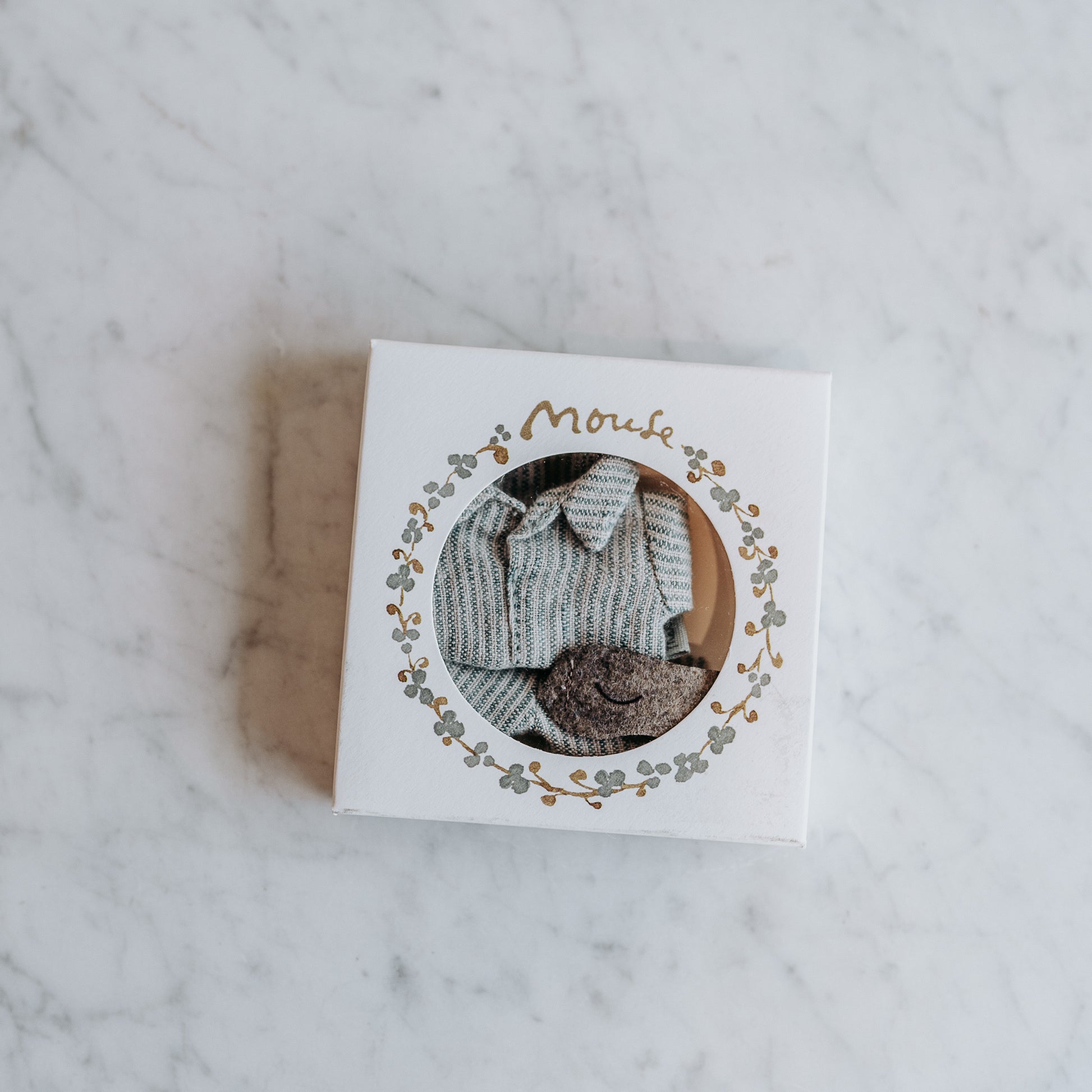 A small box with a clear window displays Maileg - Clothing for Mice by Grace & Company on a marble surface.